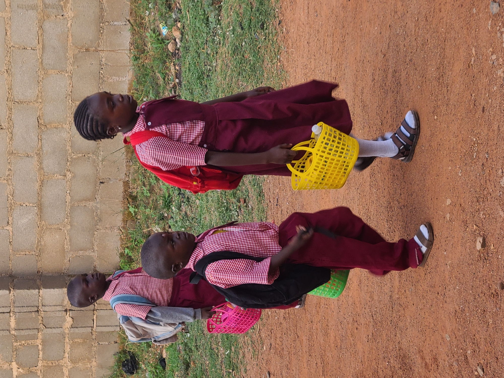 School children walk dirt roads during morning commute in Nigeria