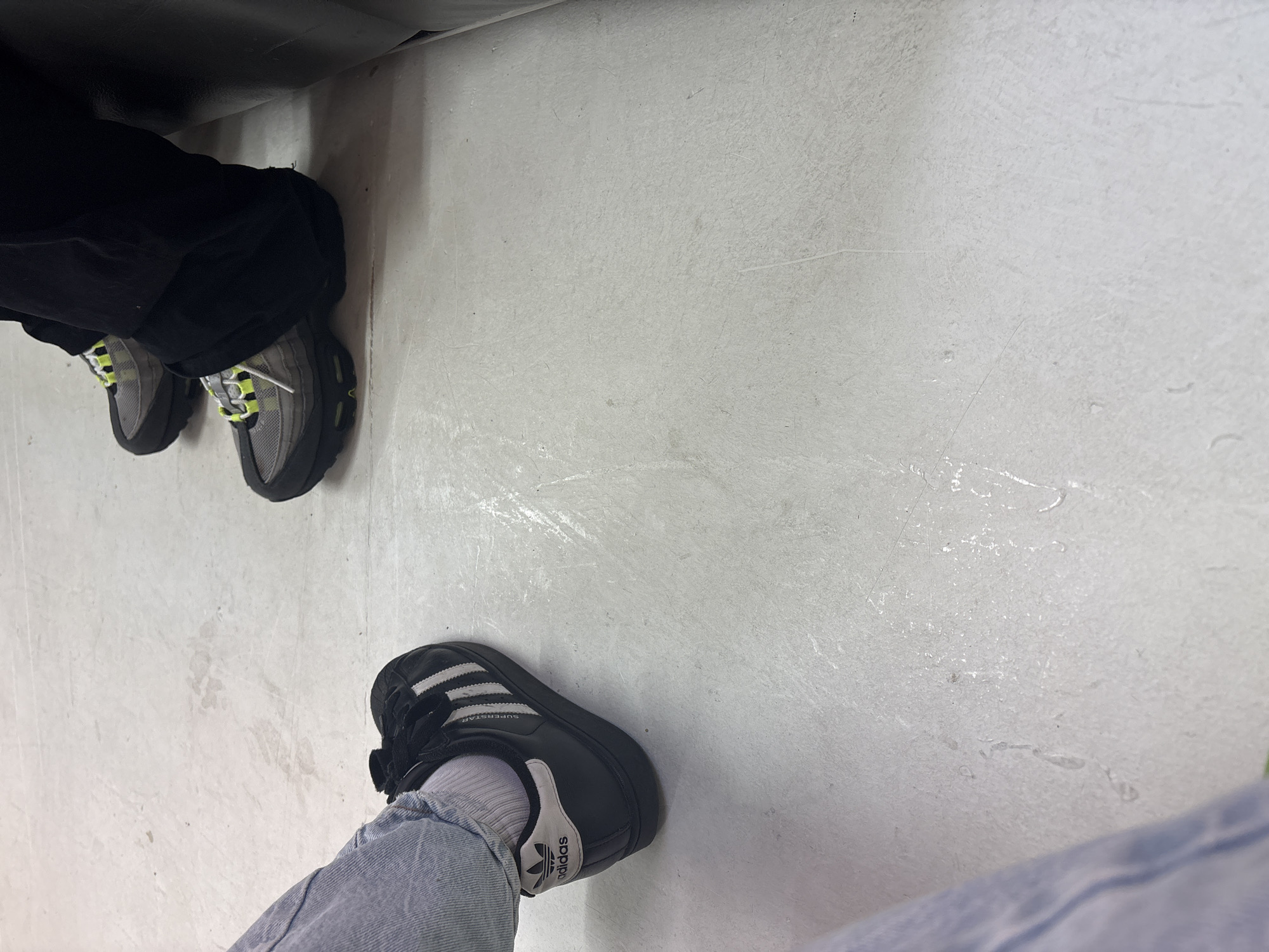 Two pairs of feet observed on Manchester floor