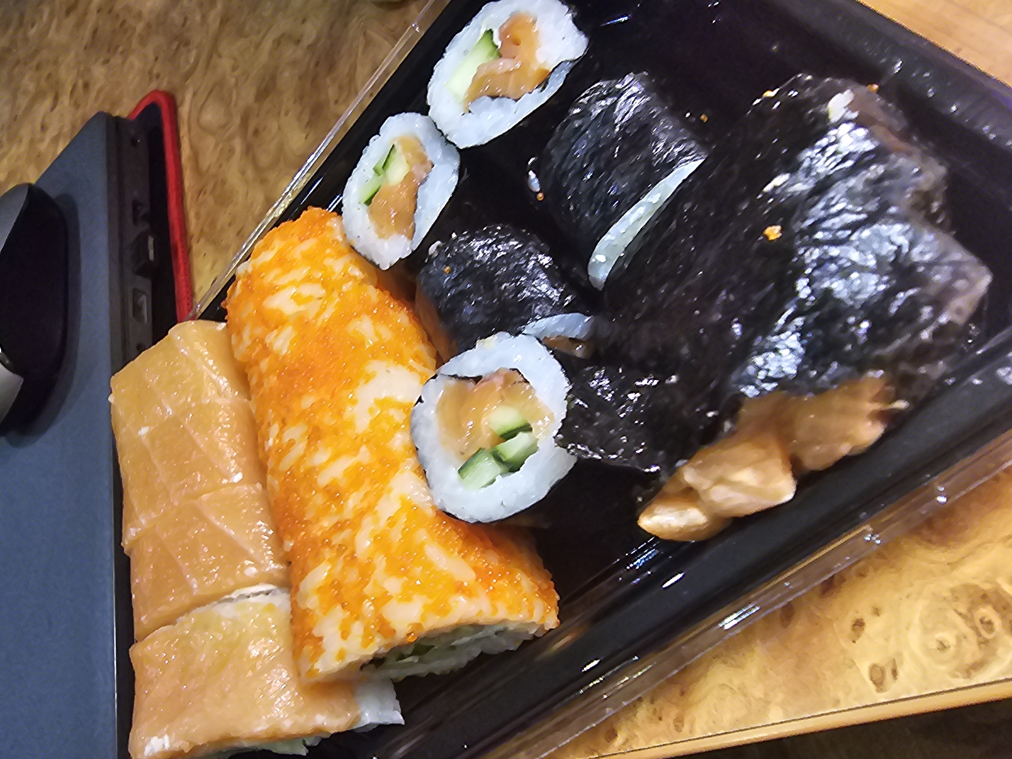 Sushi takeout container inspected up close at dinner time