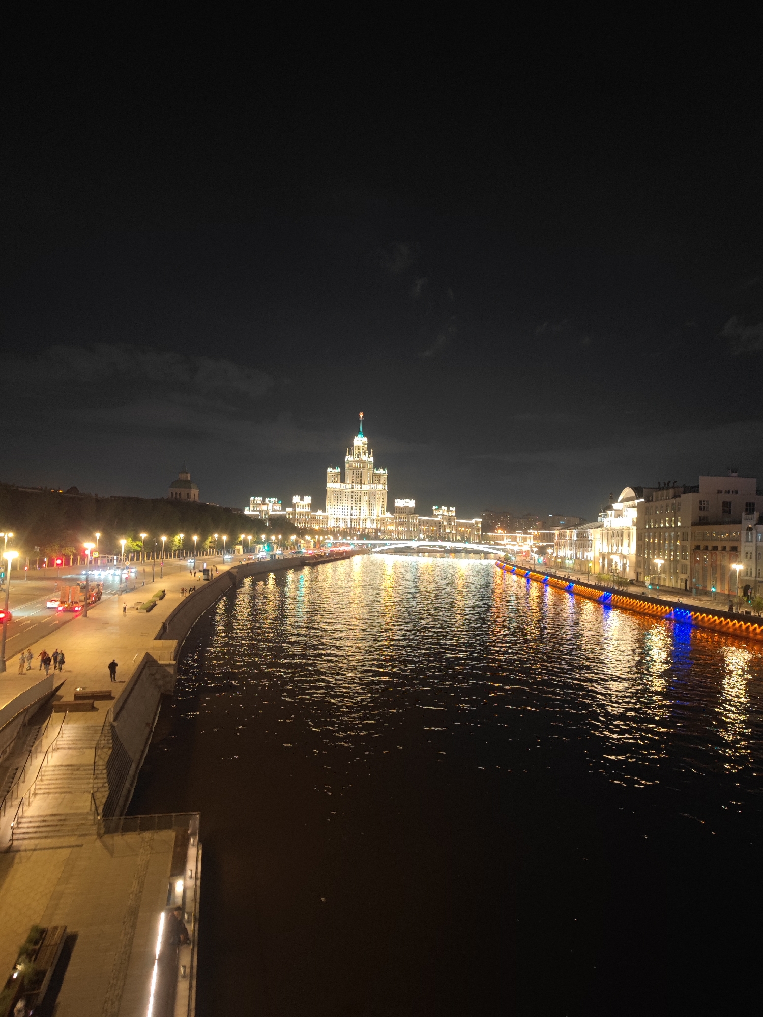 Nighttime view captures Moscow's iconic Stalinist skyscraper along Moskva River