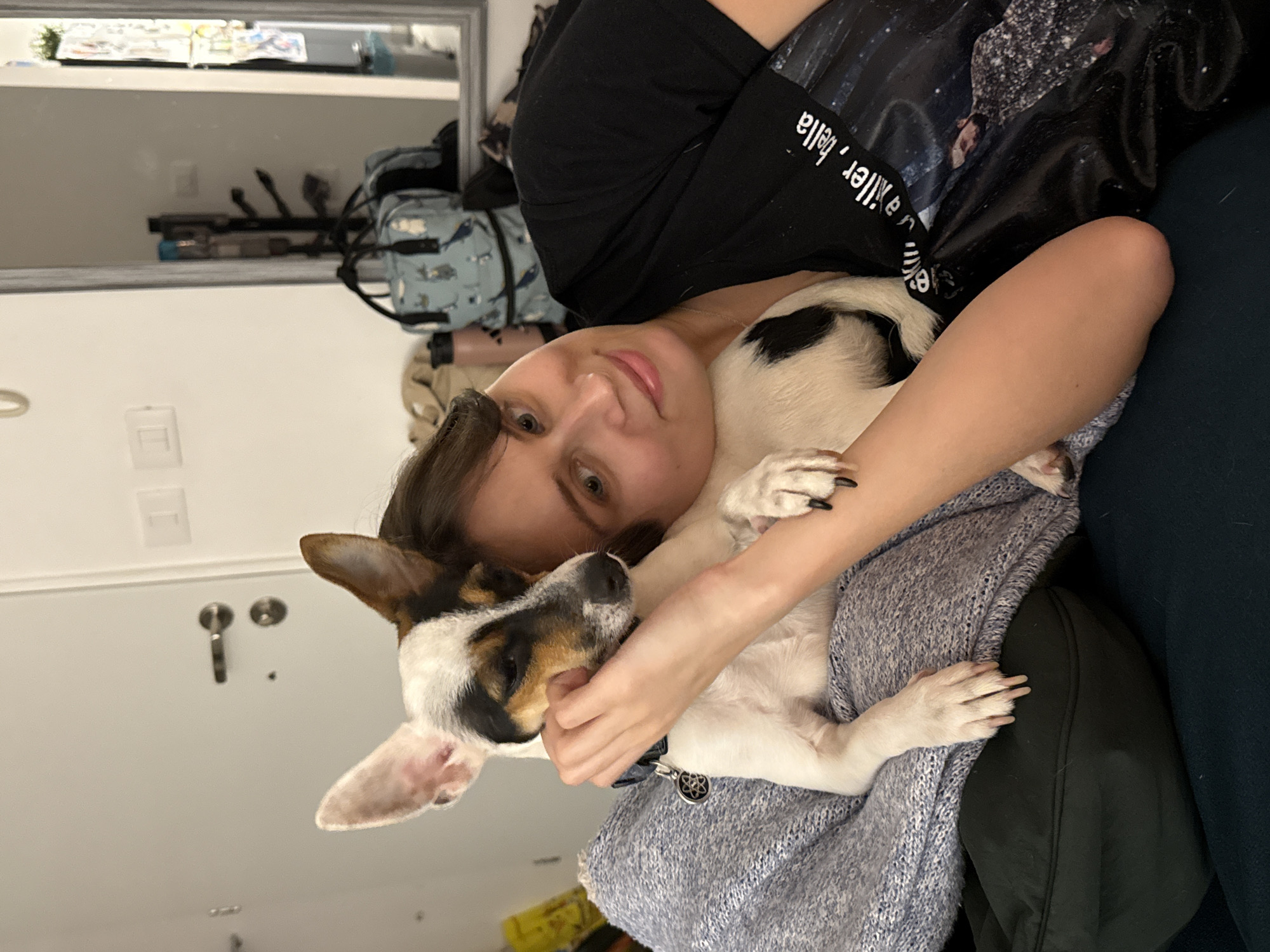 Woman relaxes with pet dog on couch in Tel Aviv