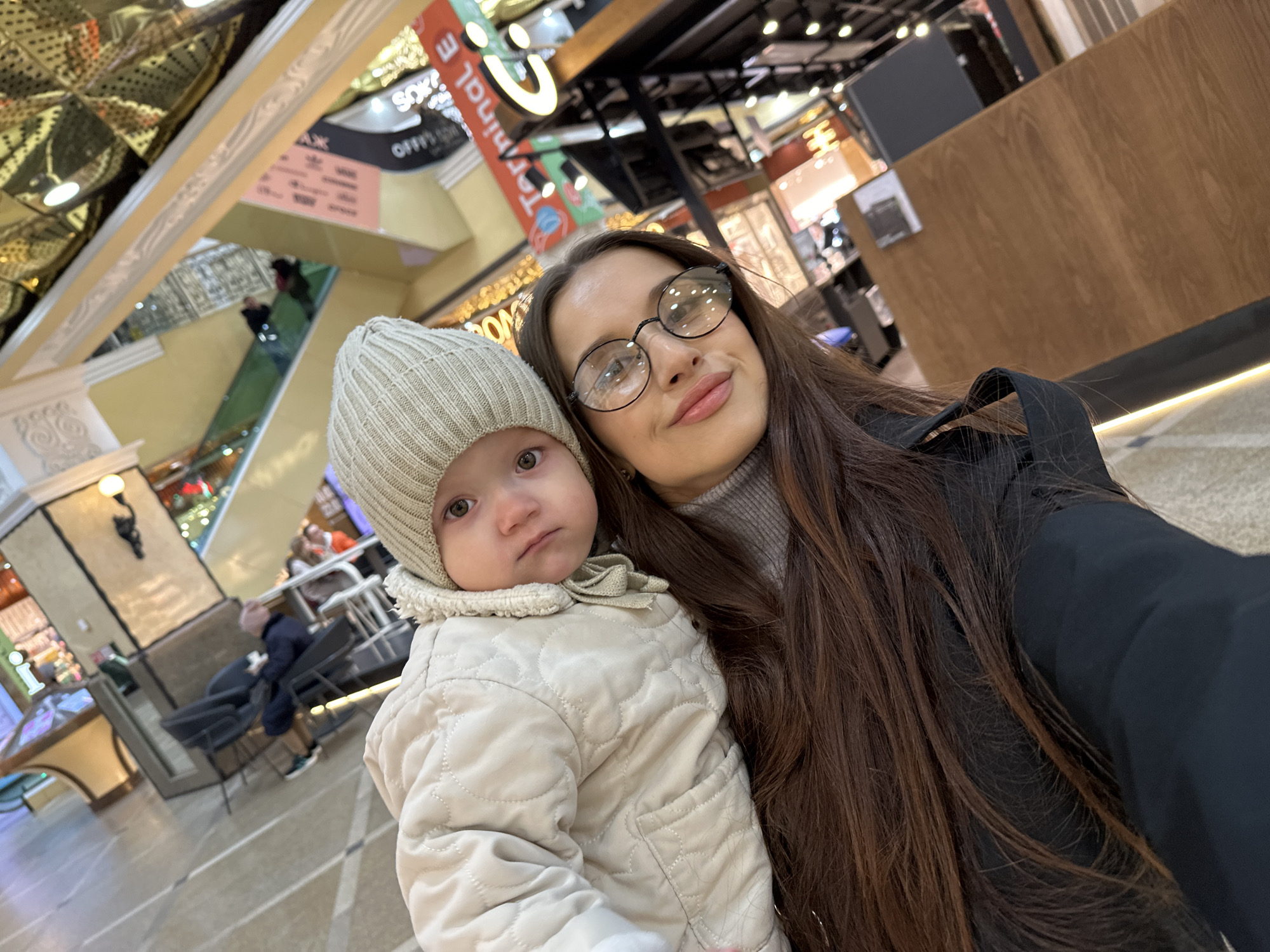 Woman and toddler shop, take selfies at Yekaterinburg mall