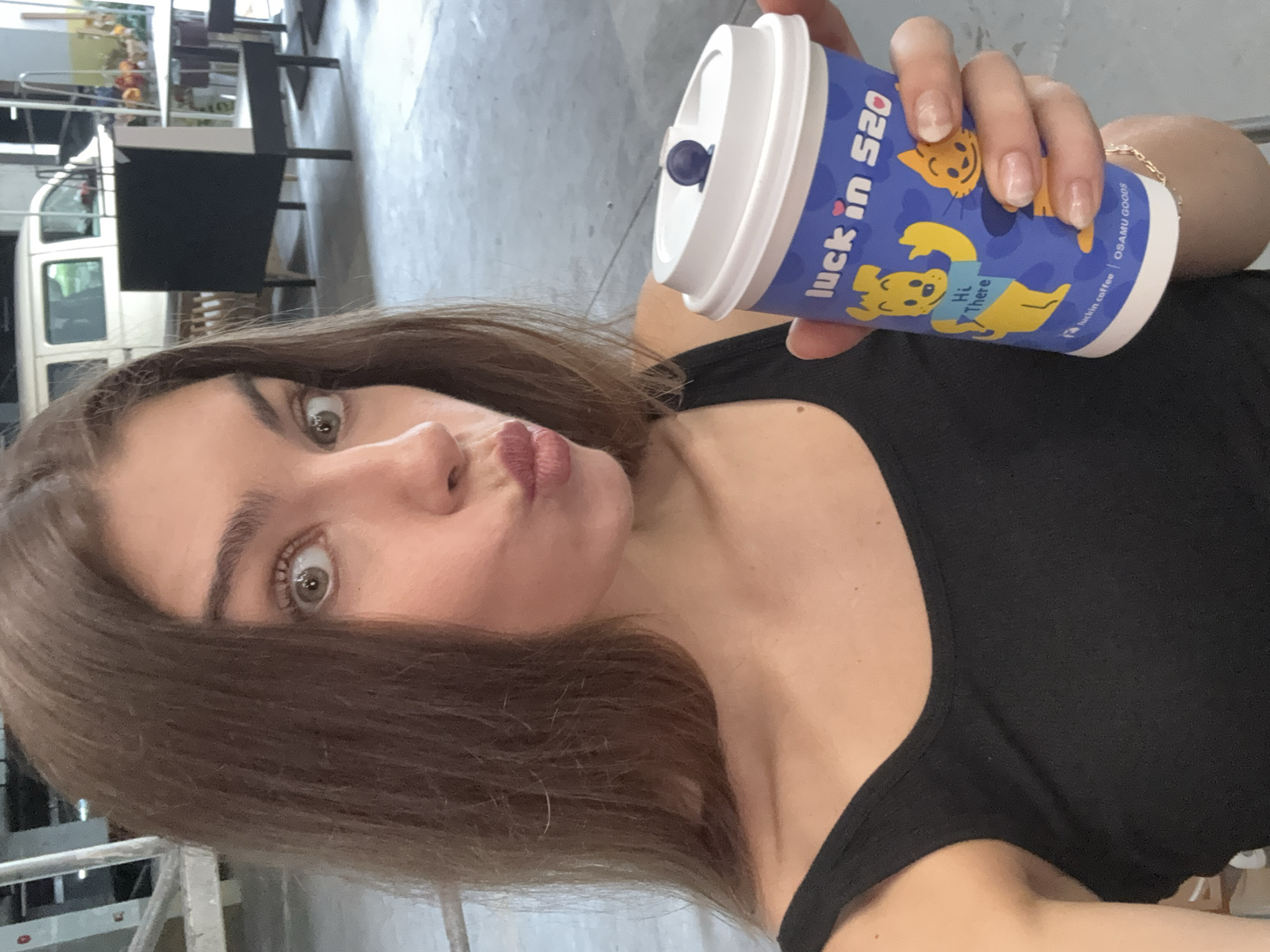 Woman poses with Luckin Coffee cup during studio shoot