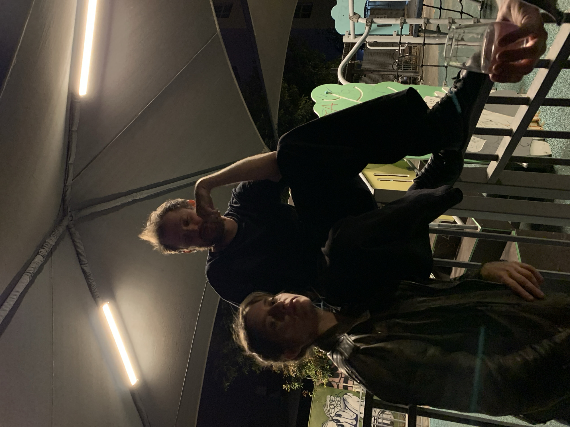 Nighttime gathering of three people in Tel Aviv outdoor area