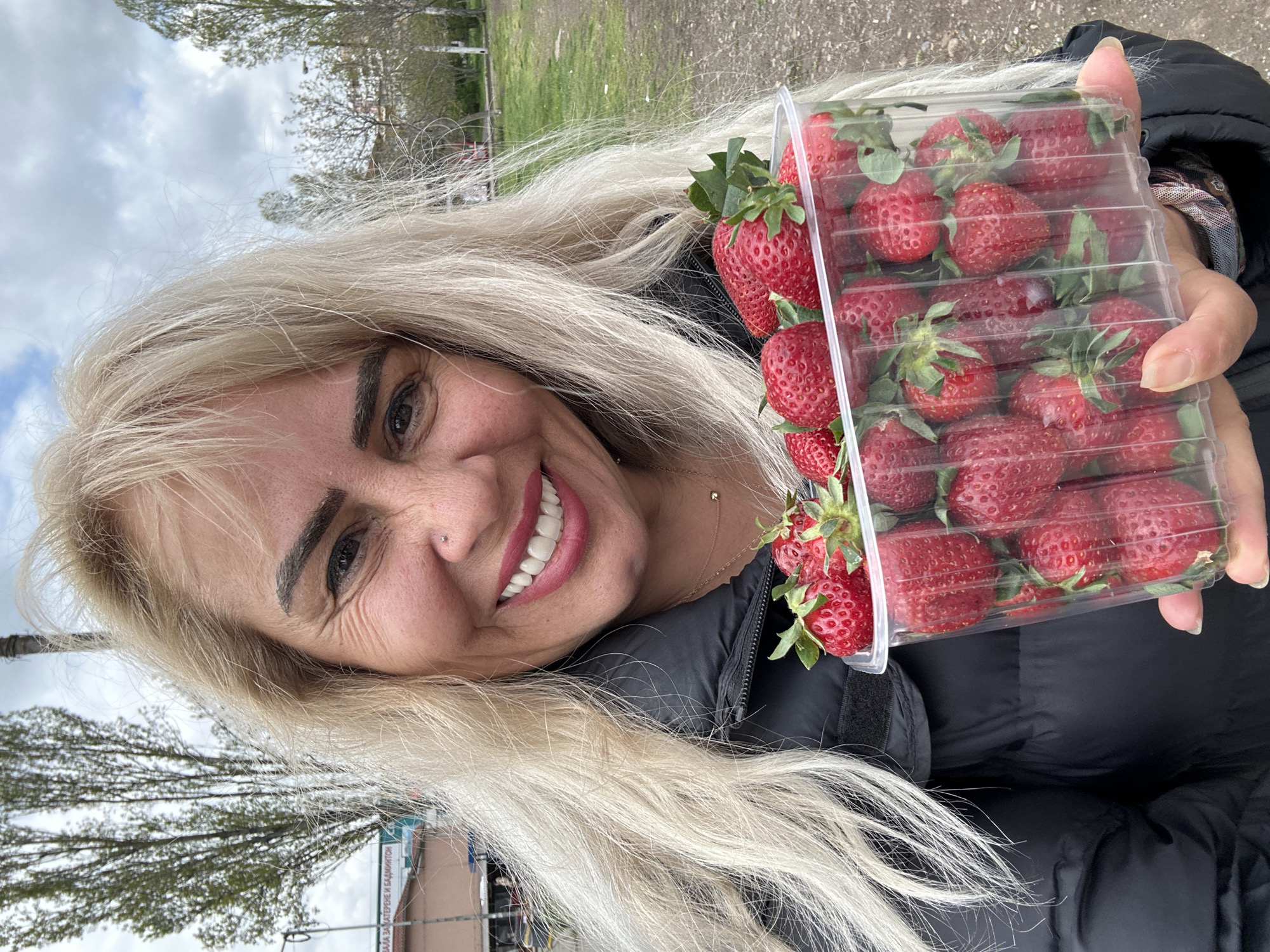Woman holds fresh strawberries outdoors in Sofia