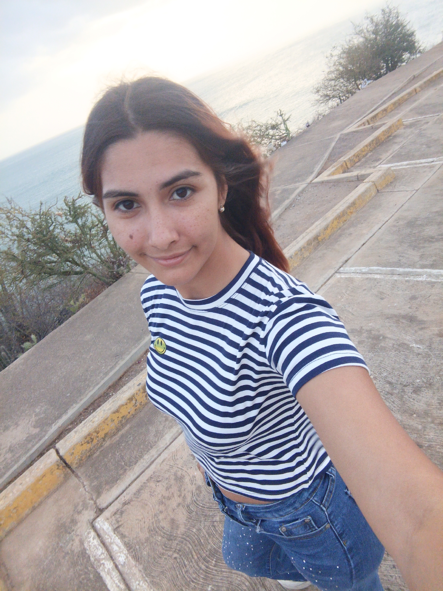 Woman takes selfies at coastal overlook in Juan Griego