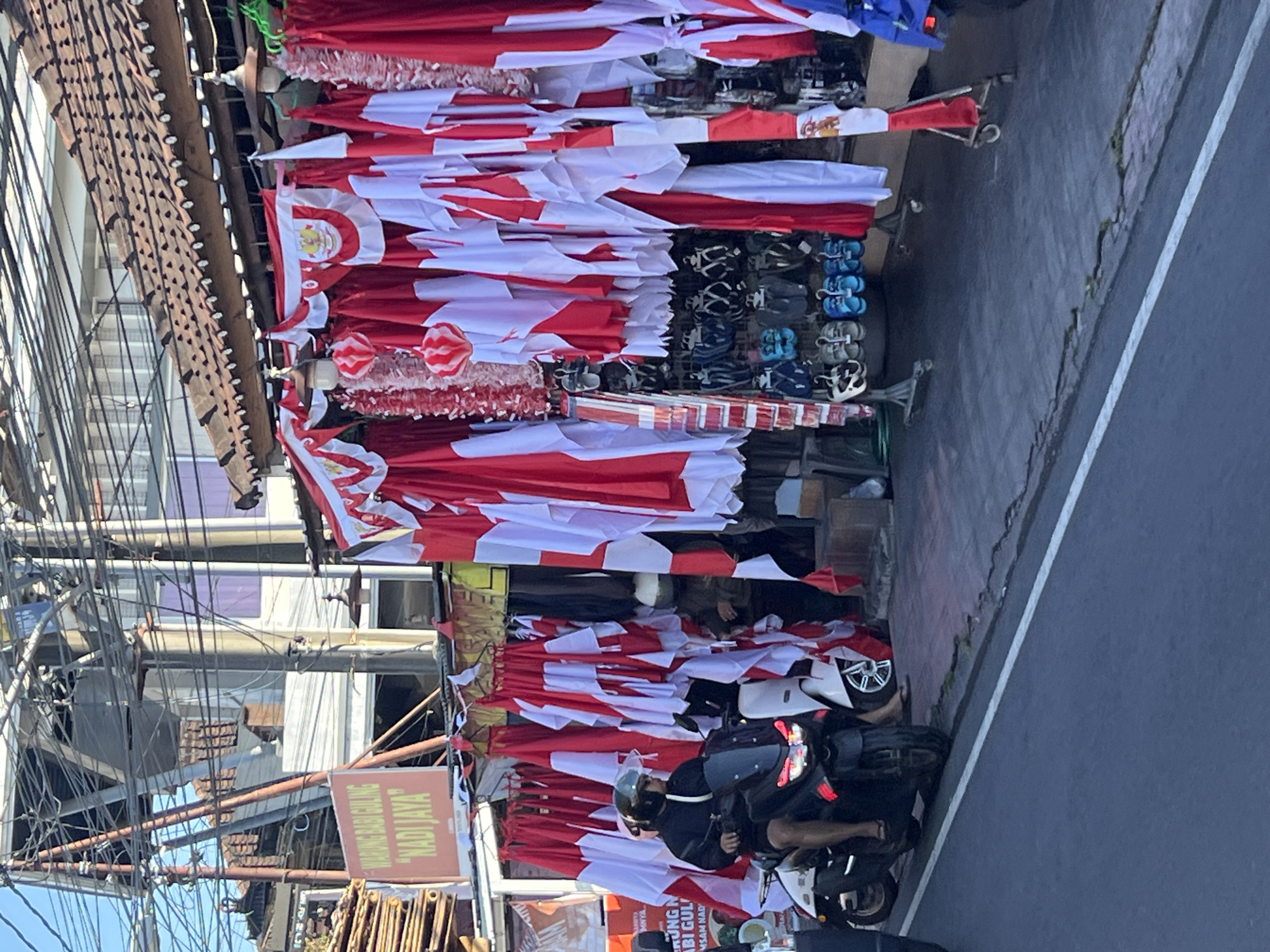 Flag vendors and motorcycle procession fill Denpasar streets