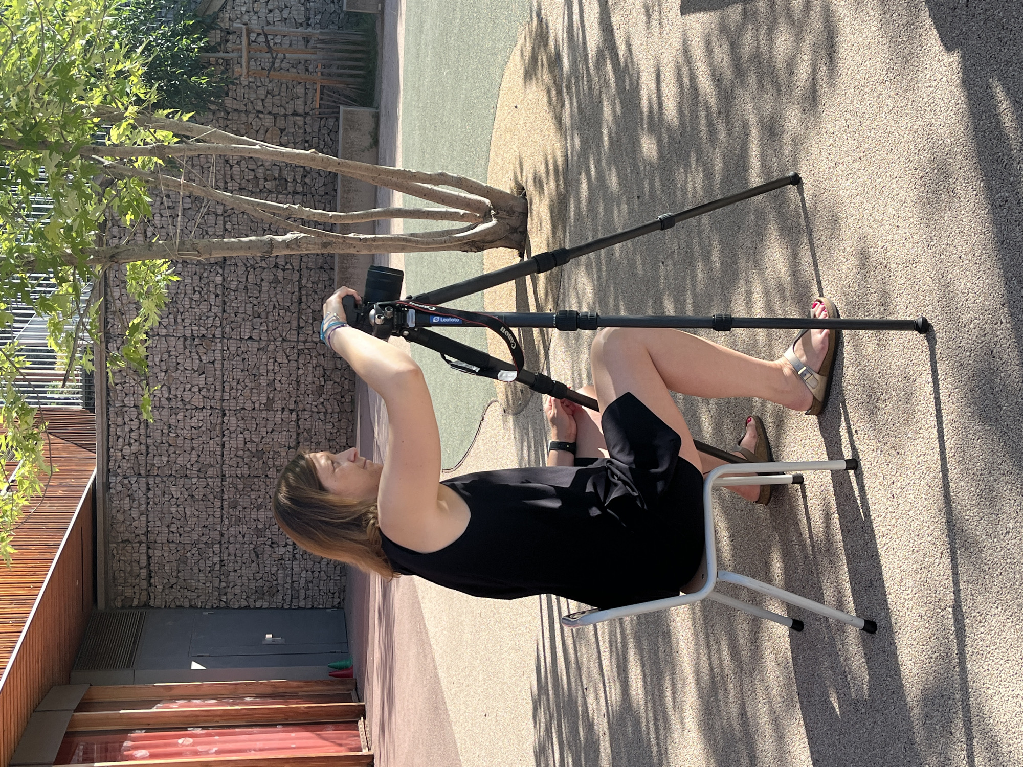 Woman sets up camera equipment for photography session in French park