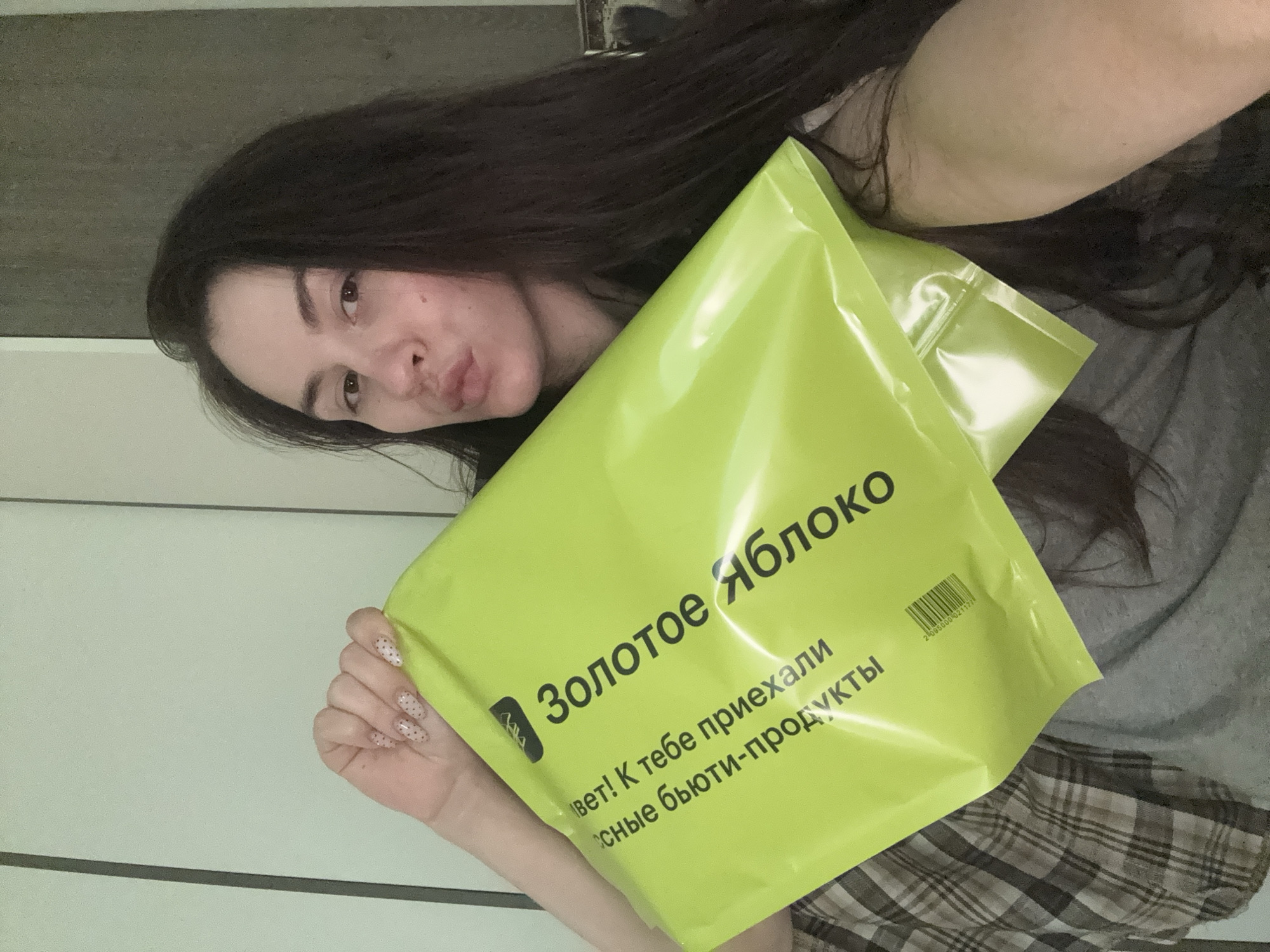 Woman carries Golden Apple beauty store bags in Saint Petersburg