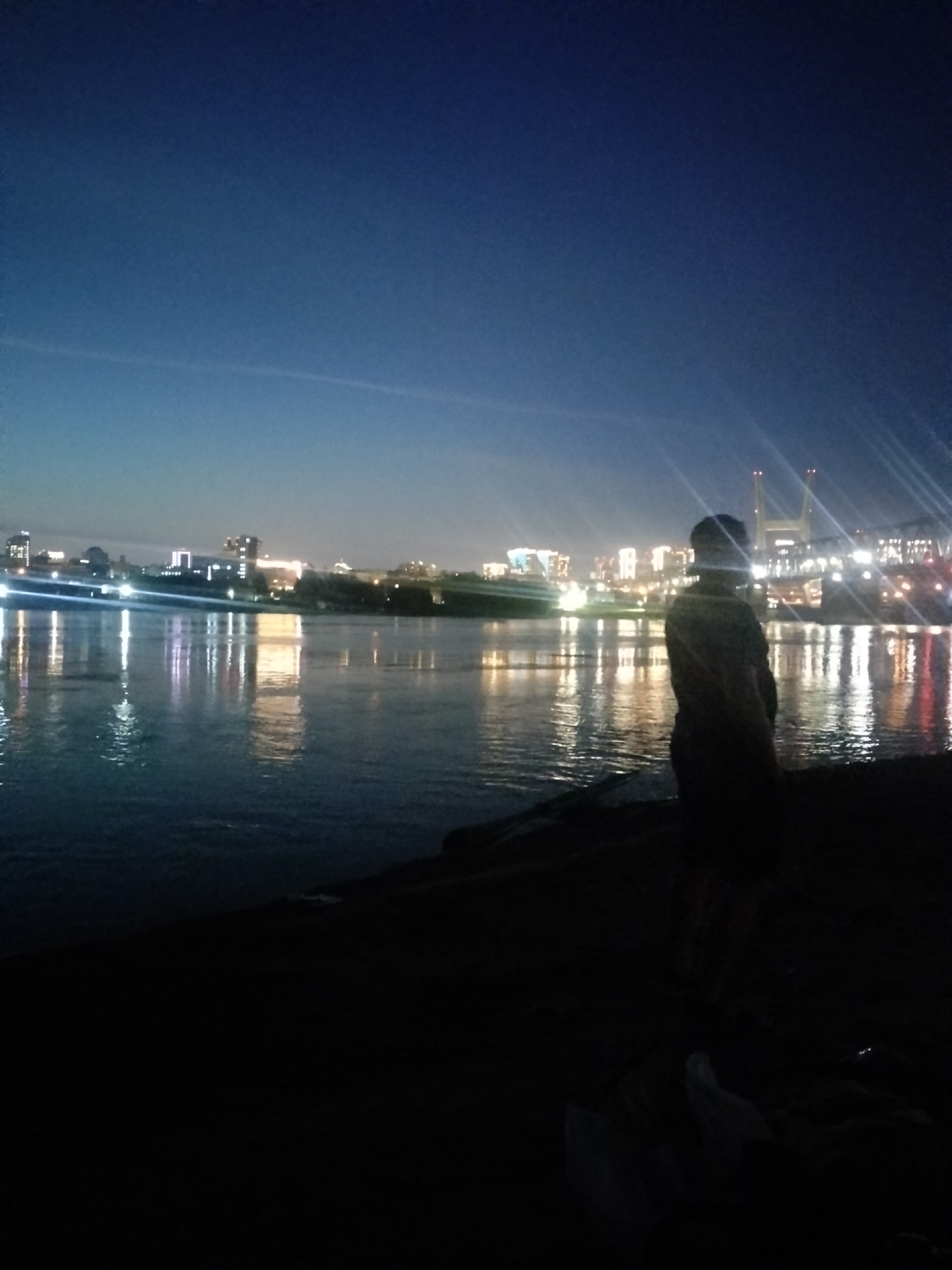 Novosibirsk skyline glows across the water at night