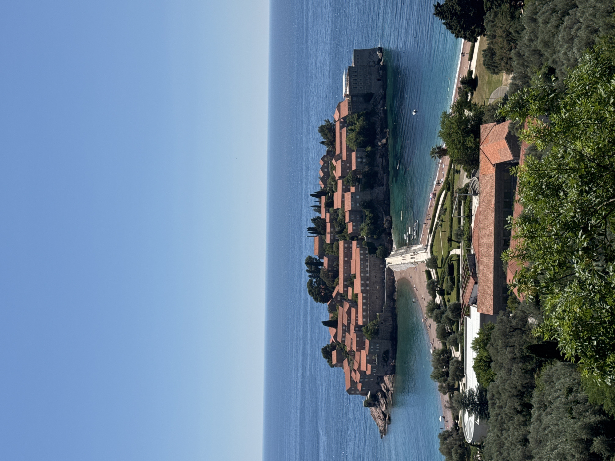 Tourist photographs iconic Sveti Stefan islet resort in Montenegro
