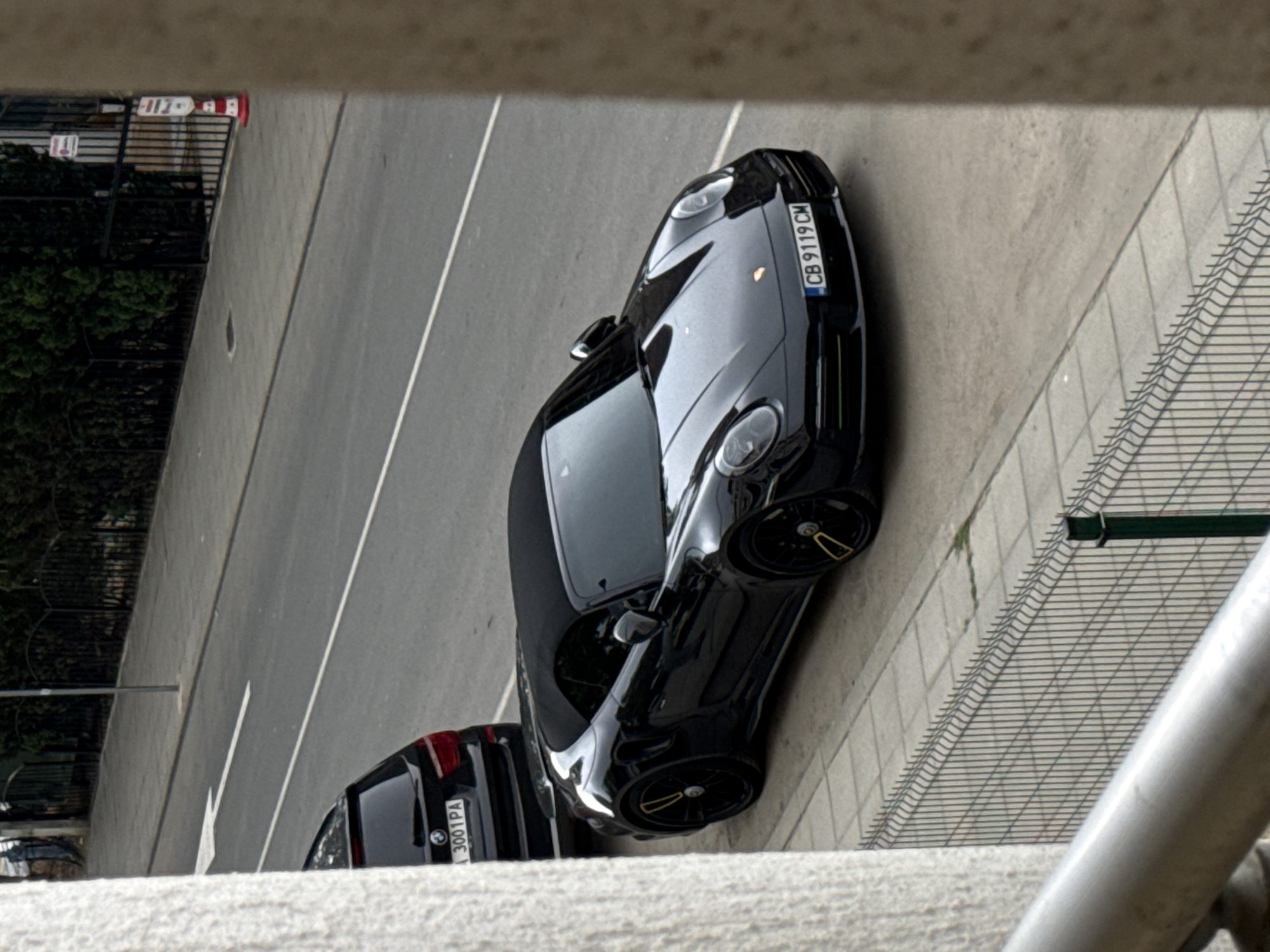 Black Porsche 911 convertible parked on rainy Nesebar streets