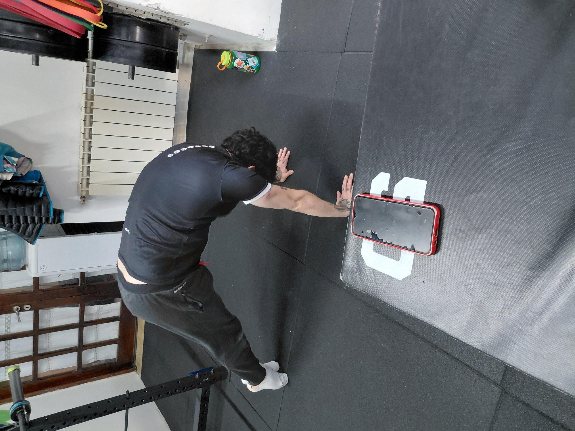 Man stretches against wall during gym workout in Ushuaia