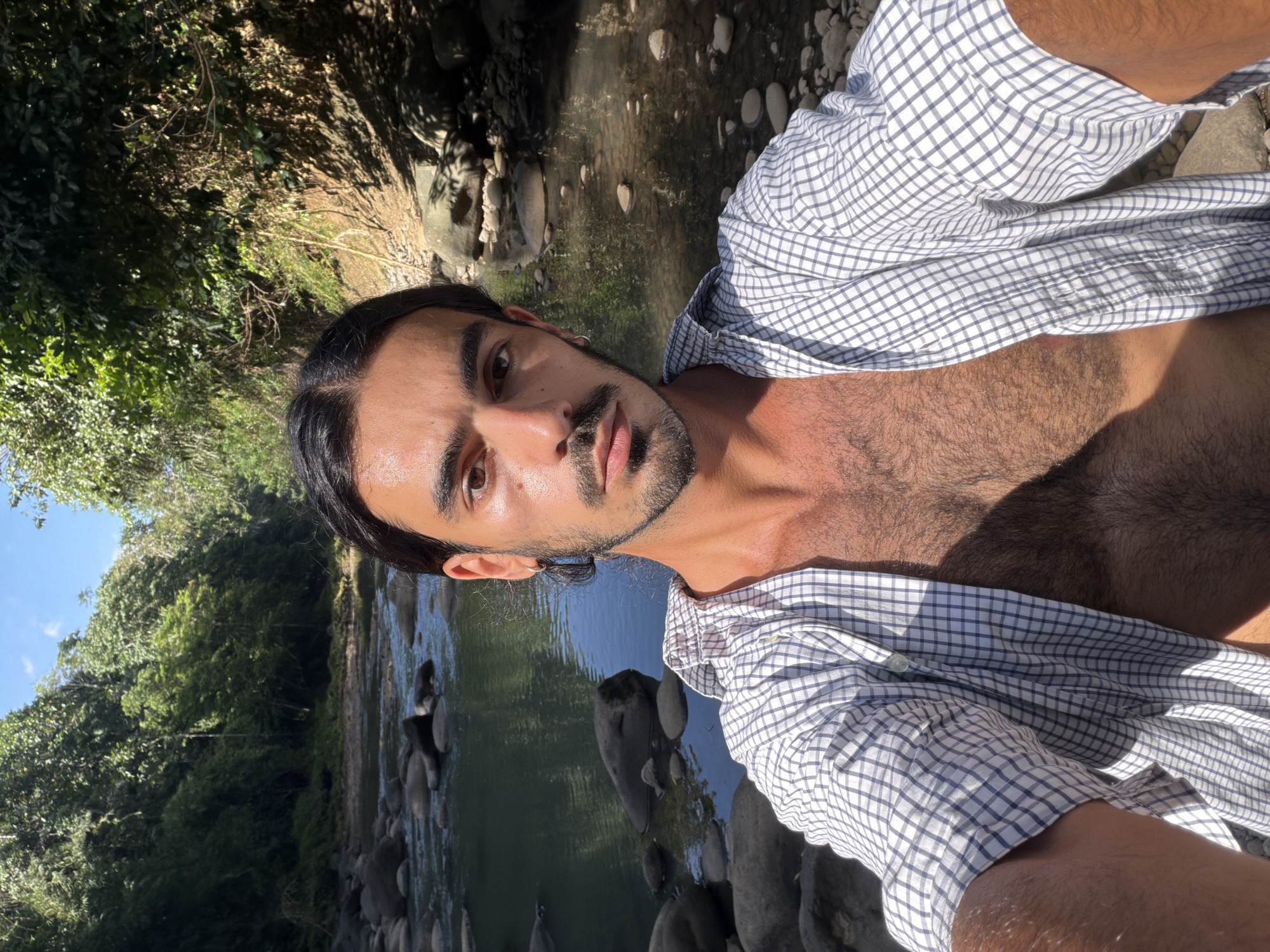 Man photographs riverside morning visit in Indonesian forest setting
