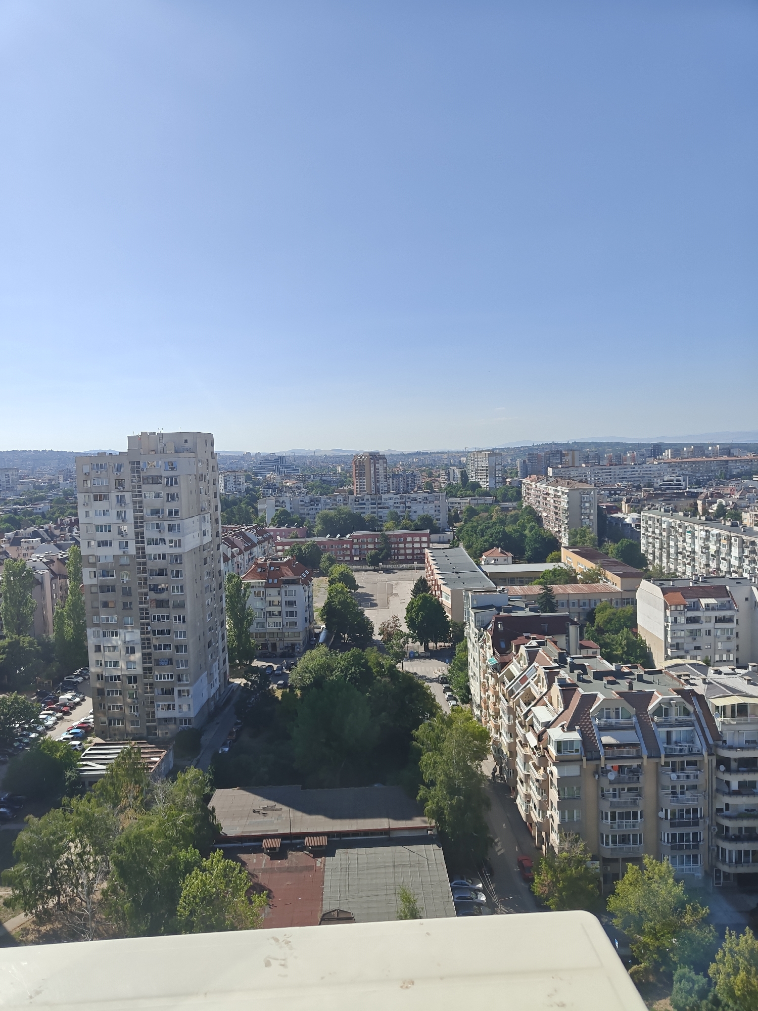 Tabby cat at home, Sofia city spread out beyond
