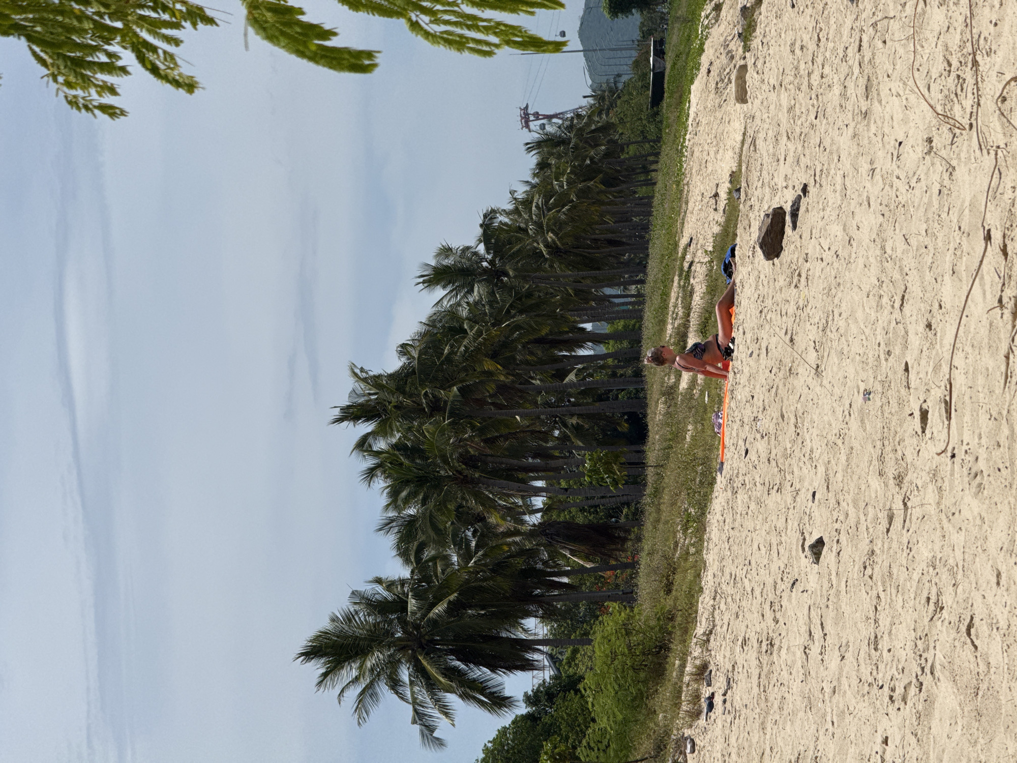 Nha Trang beach: sunbathers, swimmers, and a working dredge barge