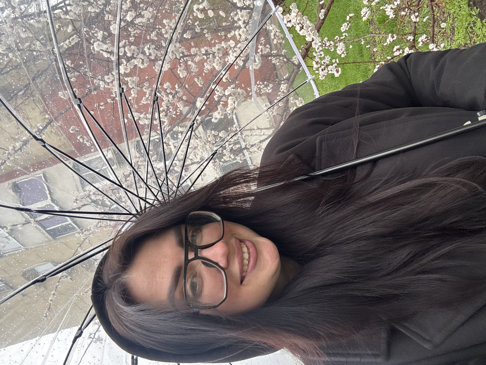 Woman shelters under clear umbrella during urban rainfall