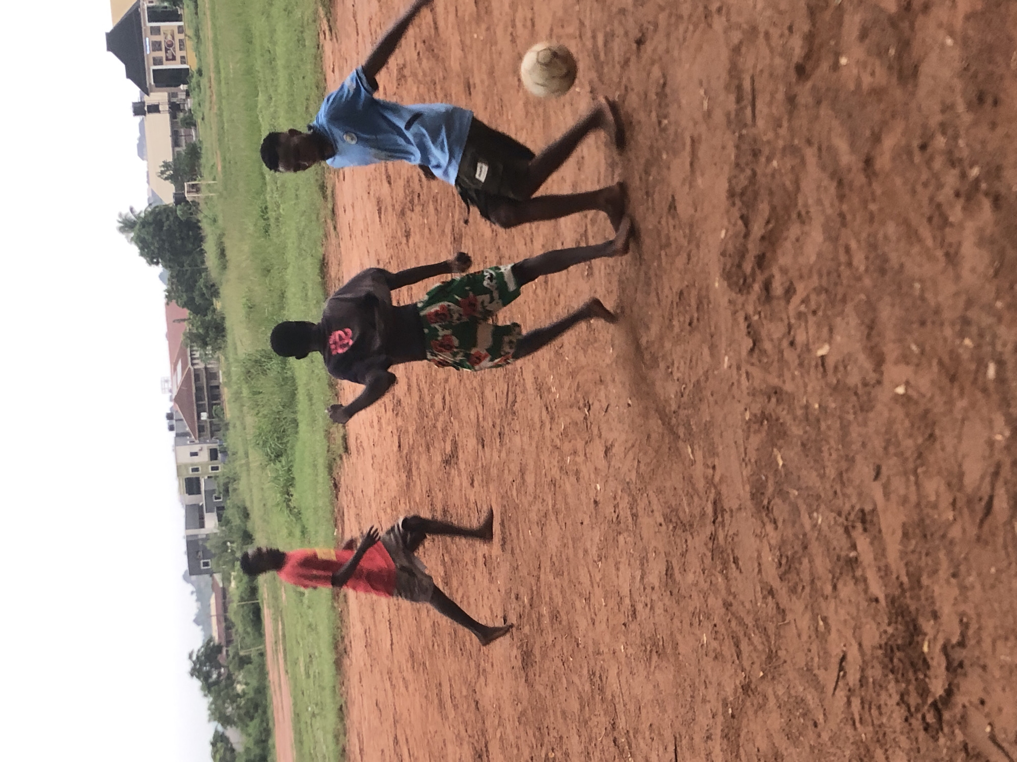 Nigerian youth play football, gather on dirt fields