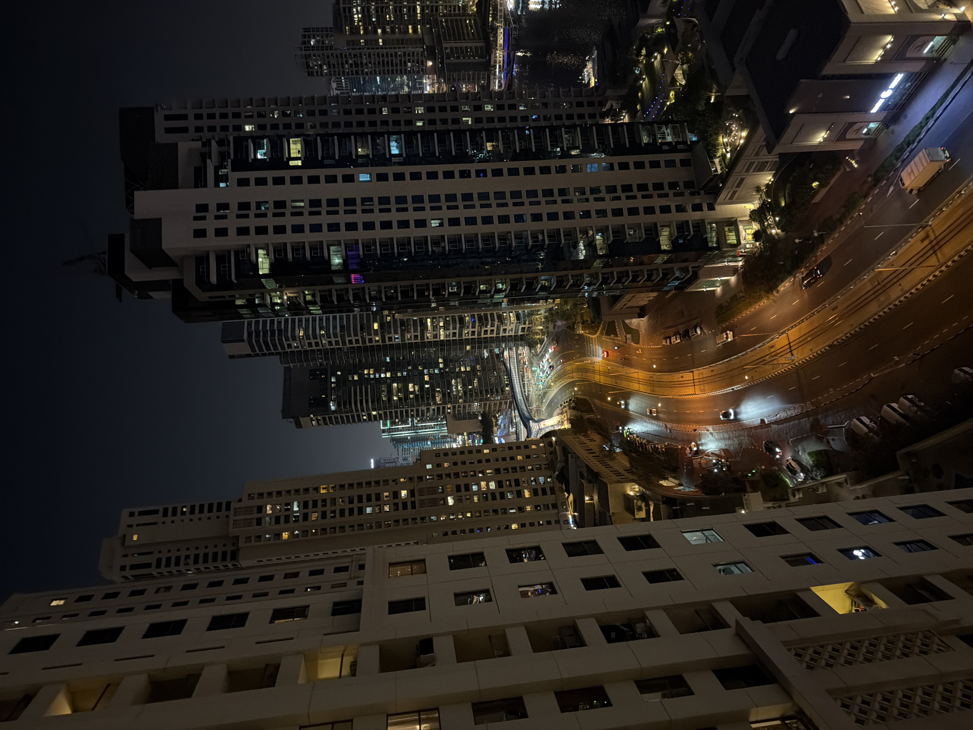 Nighttime aerial views capture illuminated Dubai Marina district evening scene