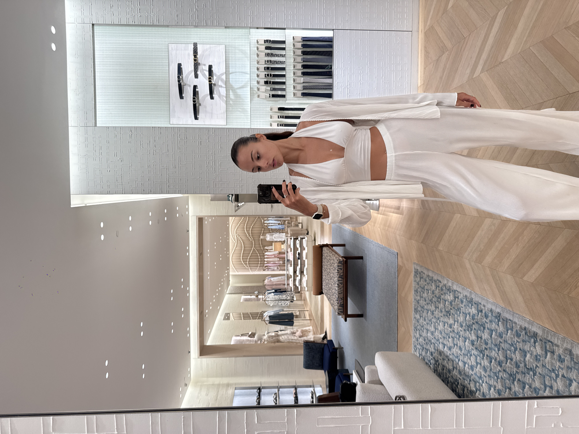 Woman takes mirror selfie at retail store in Thailand