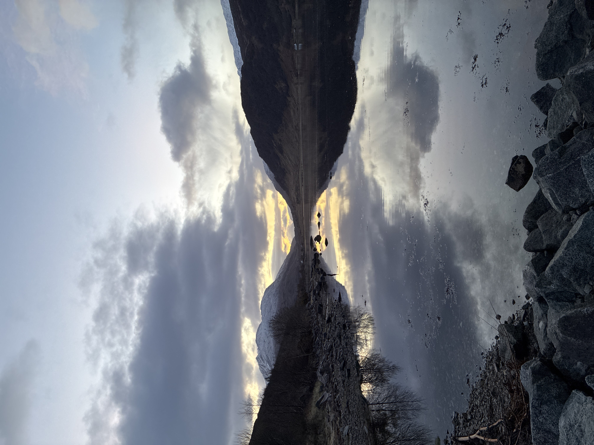 Mirror-like water reflections captured under stormy skies in Strontian