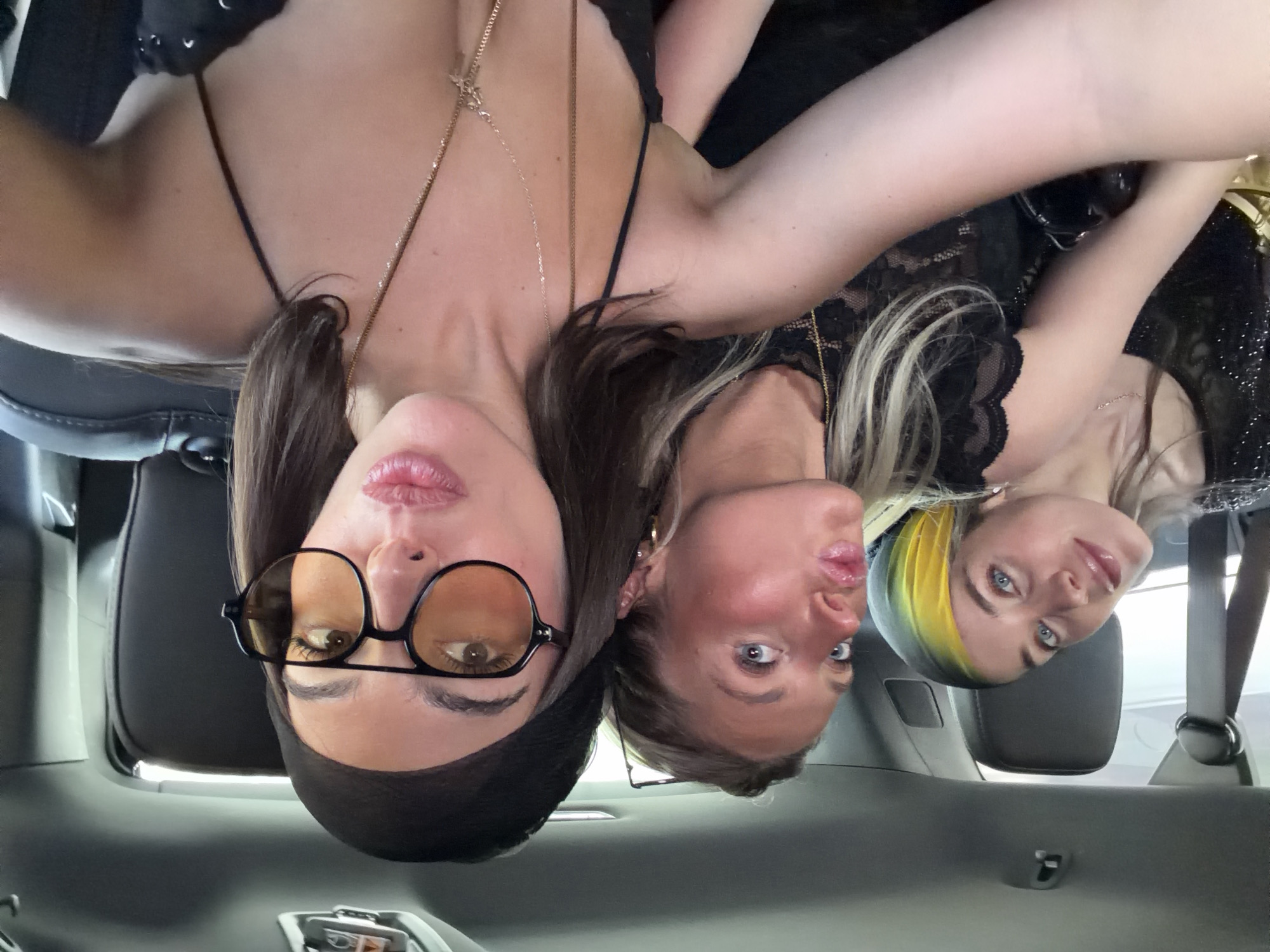Three women gather close together inside vehicle in La Quinta
