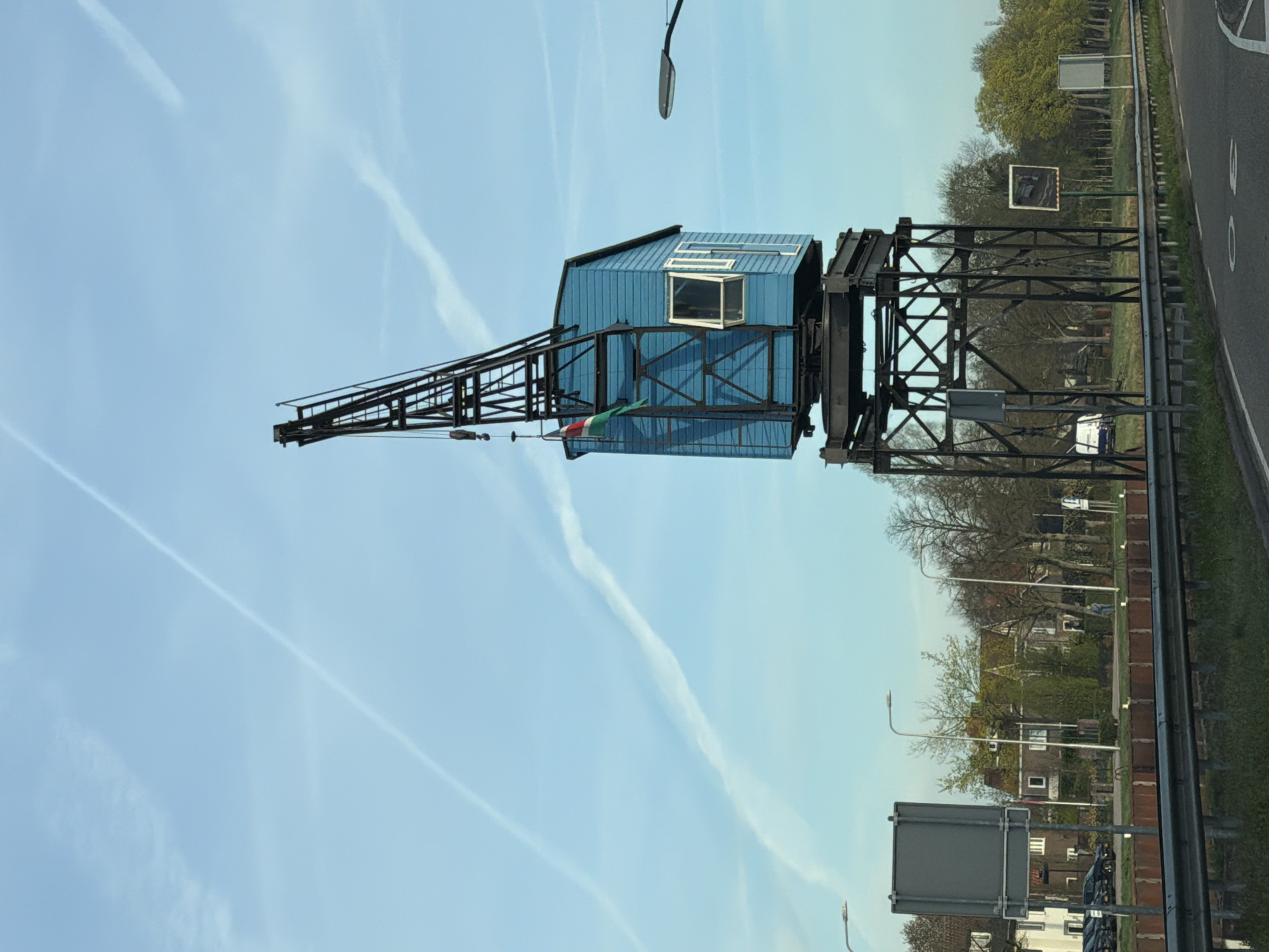 Blue crane photographed against contrailed sky in Beek en Donk