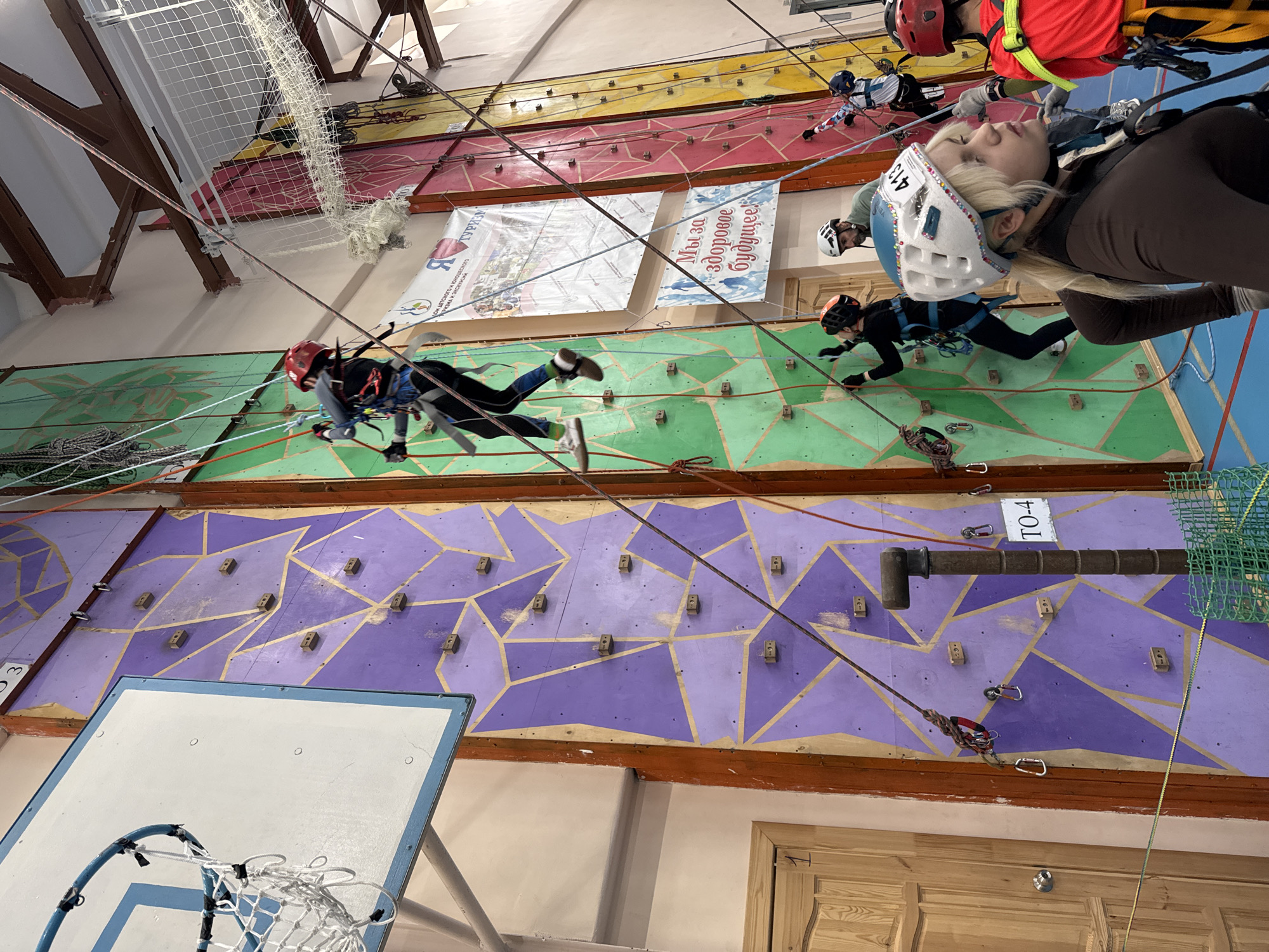 Climbers practice at indoor gym with colorful walls