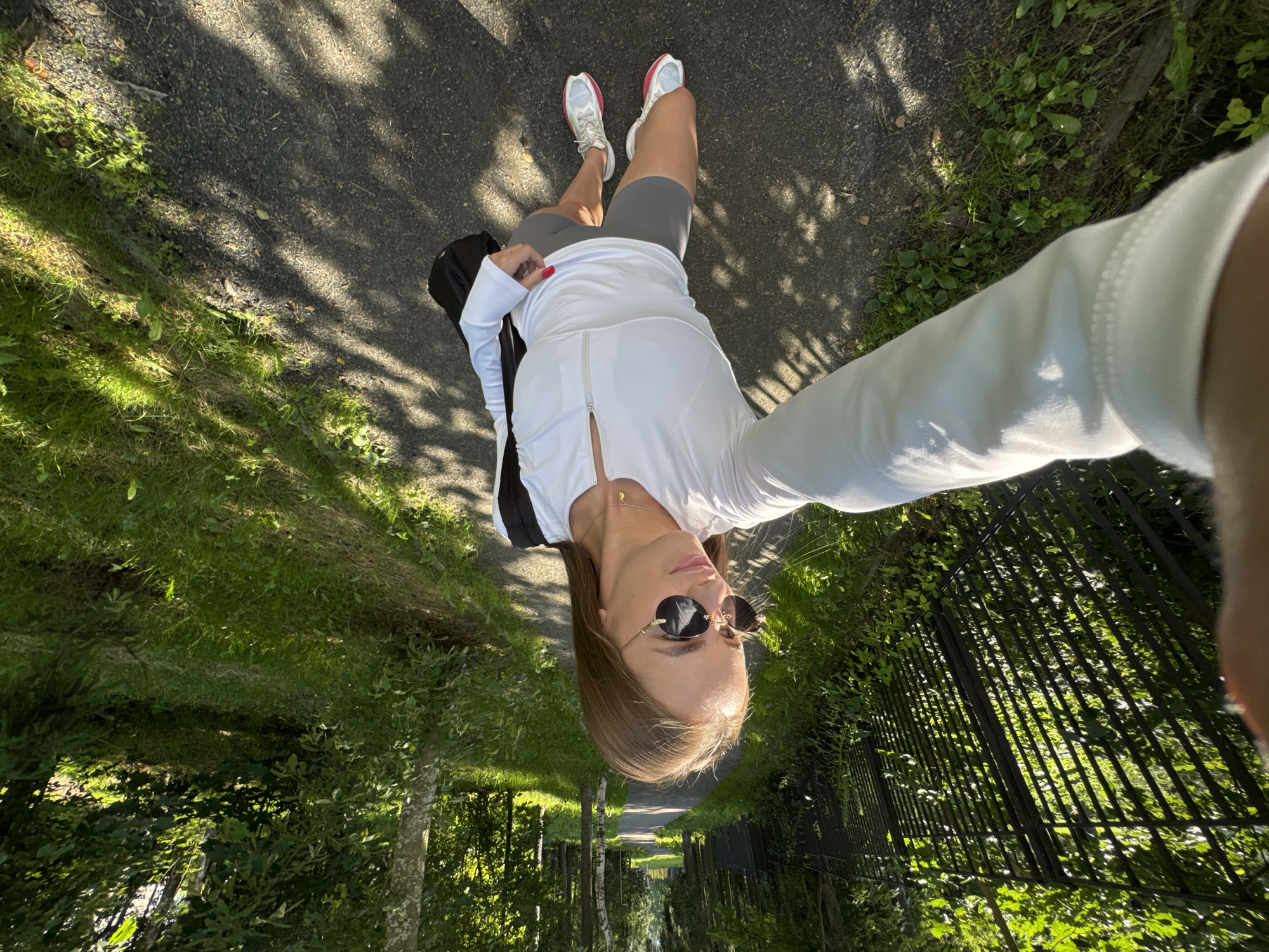 Casual walk through a park, selfie in hand.