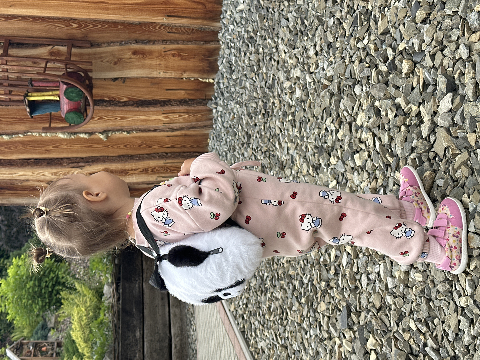 Kid in Hello Kitty gear on a gravel surface in Wisła