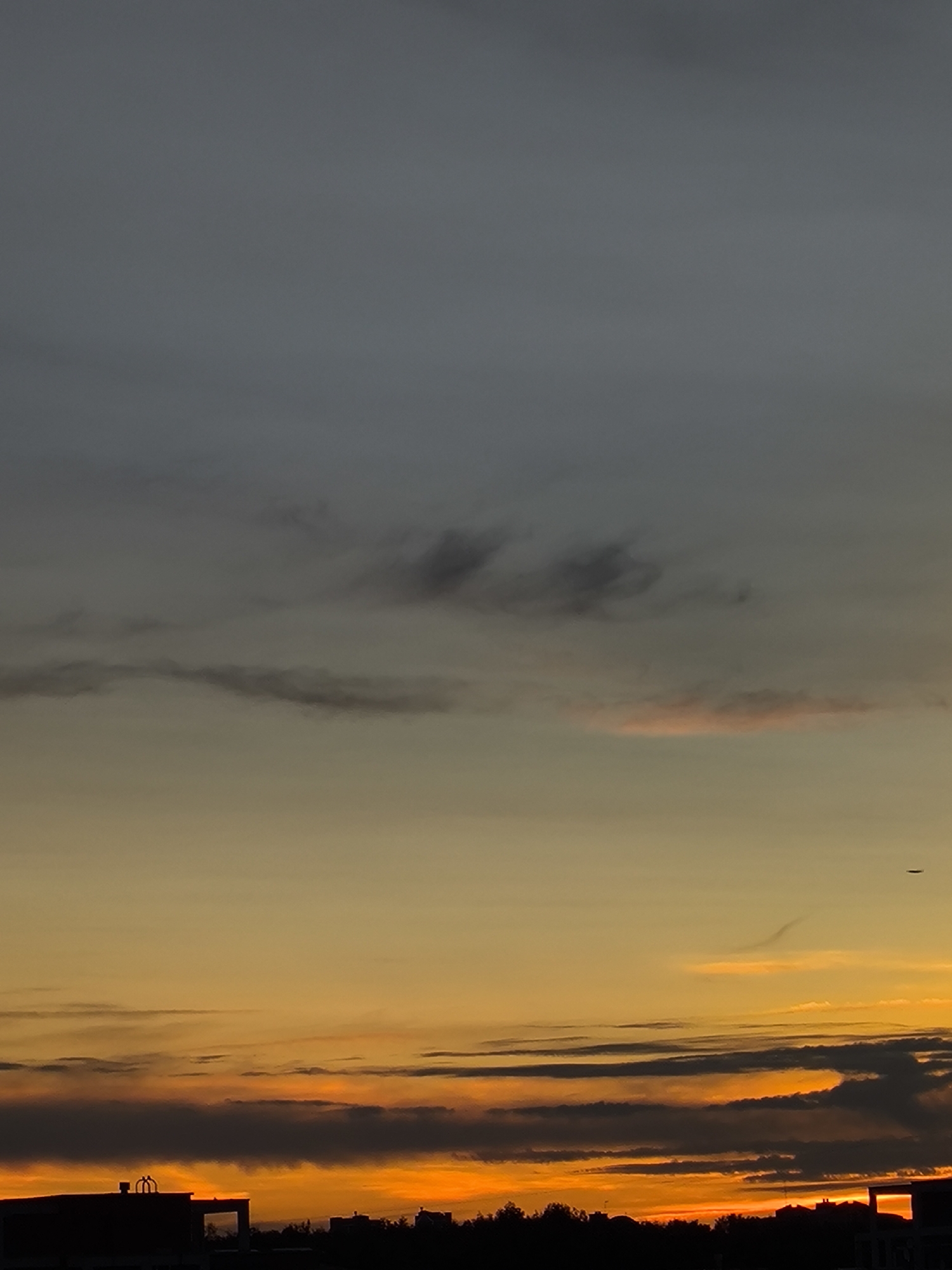 City skyline glows through a layered sunset