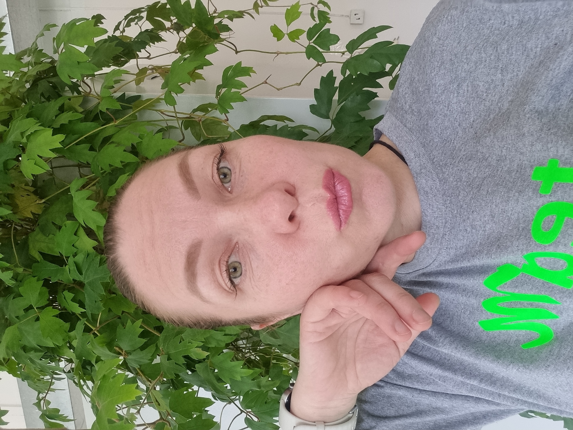 Woman takes indoor selfies near plant in Kemul, Russia