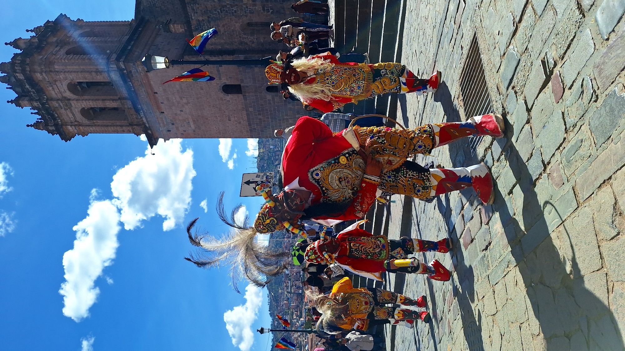 Traditional costumed performers gather on Cuzco cobblestone street