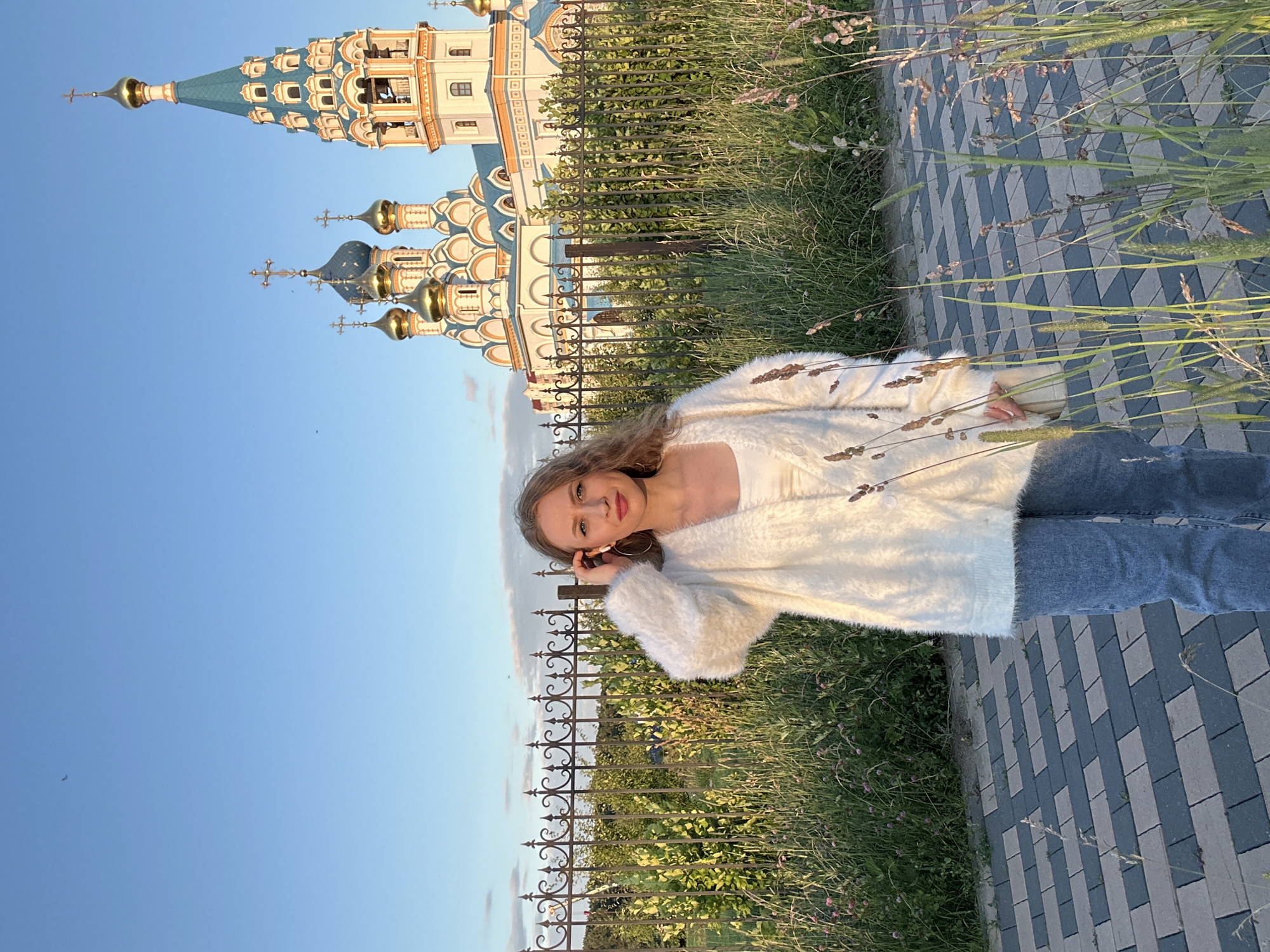 Casual moment on a Moscow walkway, hand raised to ear