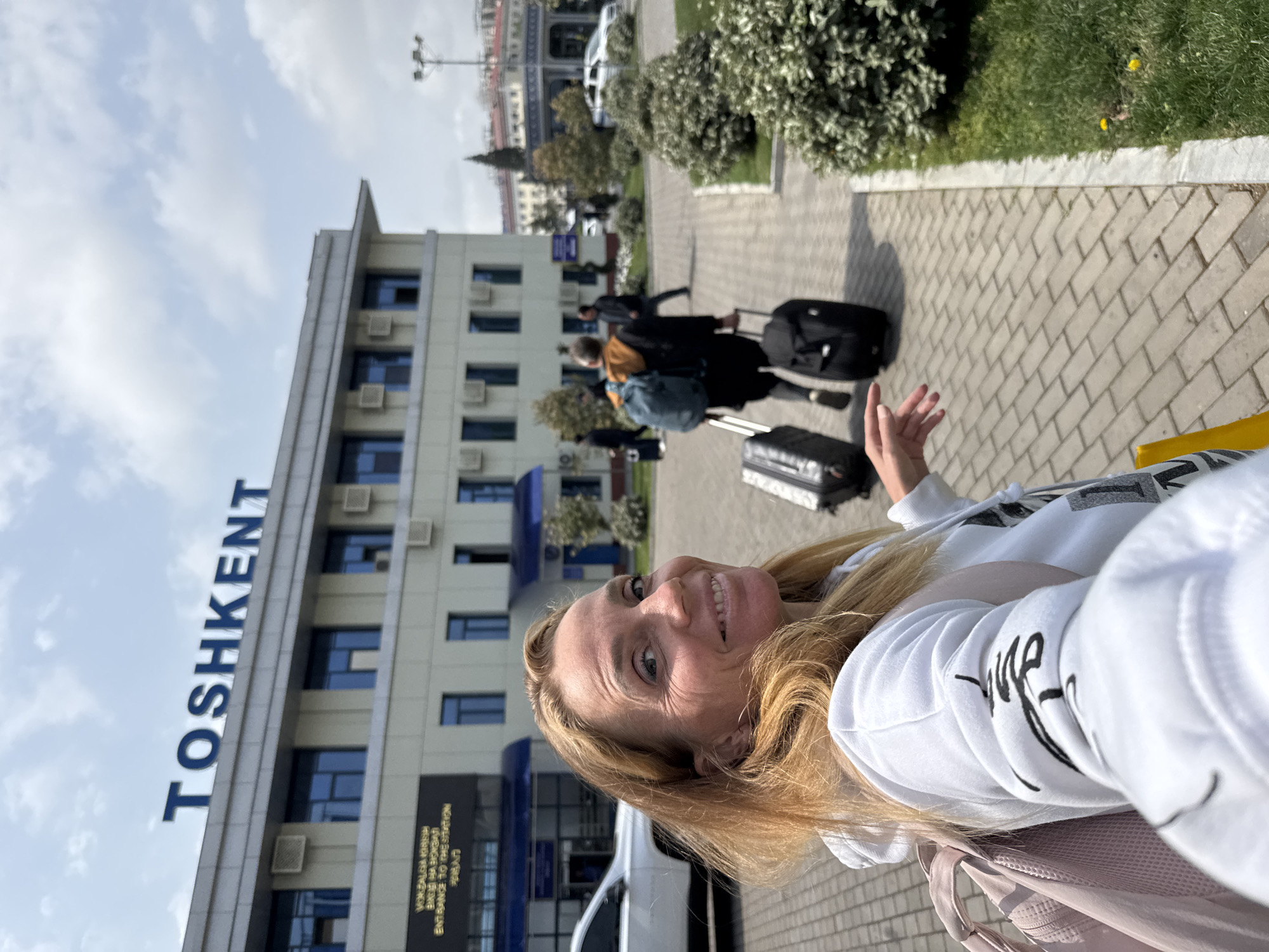 Woman photographs herself outside TOSHKENT building in Uzbekistan