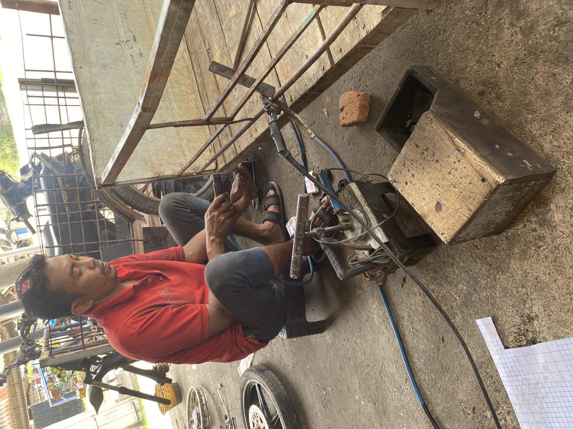 Roadside welding and motorcycle repair in Bayu, Indonesia