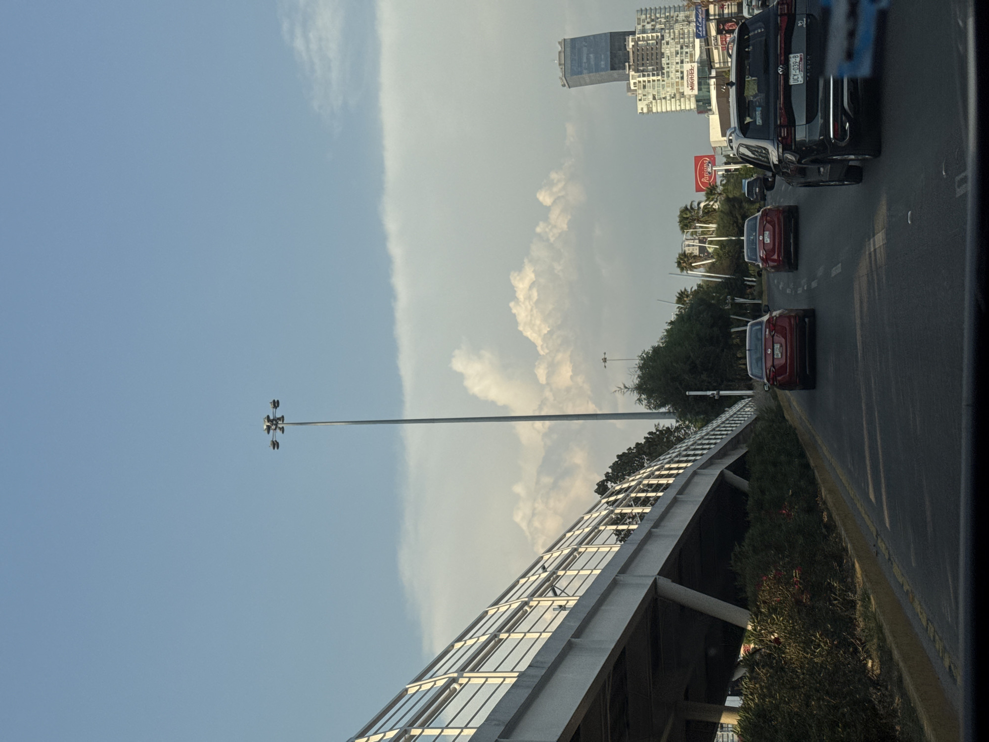 Traffic flows through Puebla streets near Coca-Cola billboard