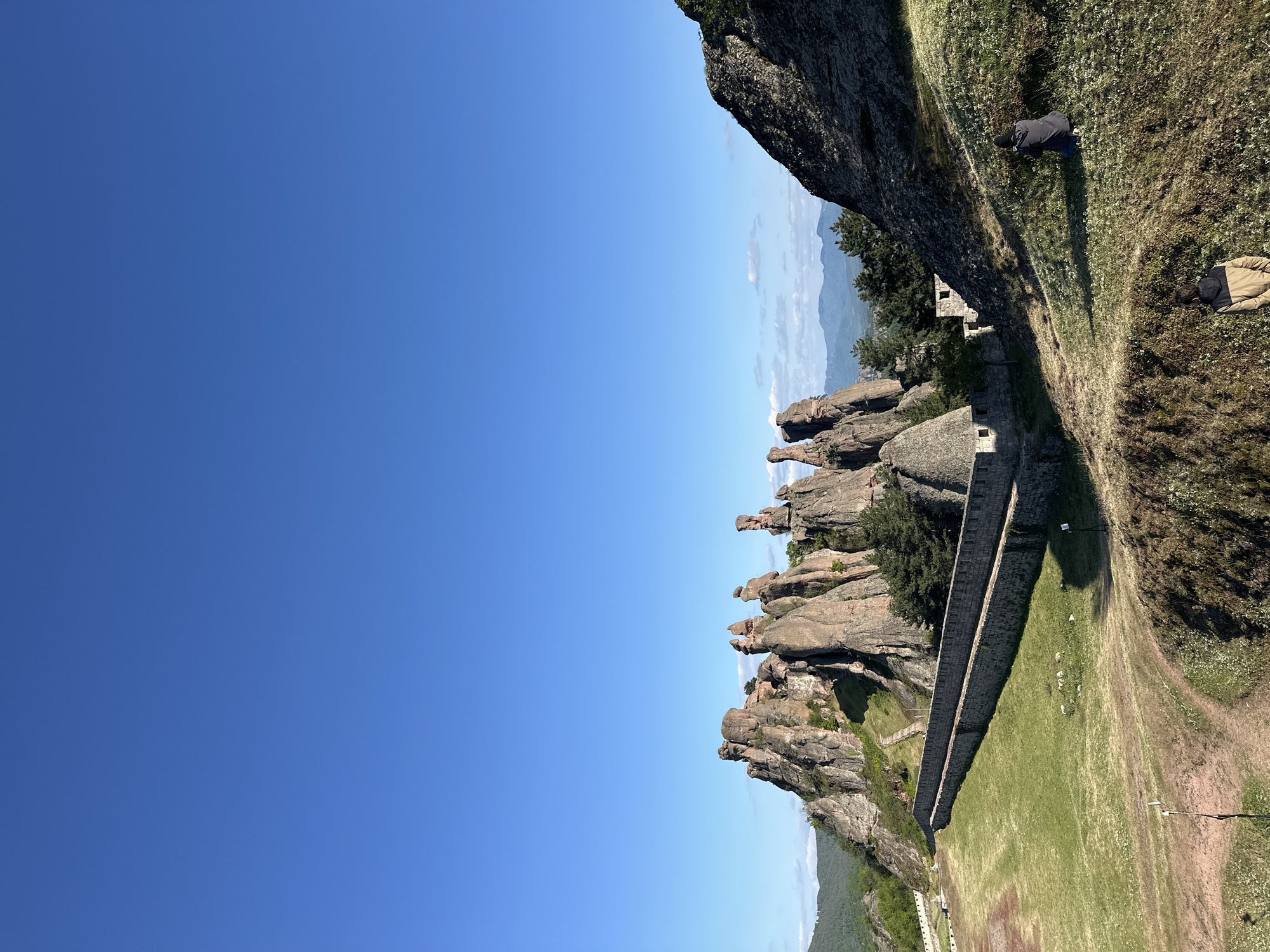 Tourist documents medieval fortress and rock formations in Bulgaria