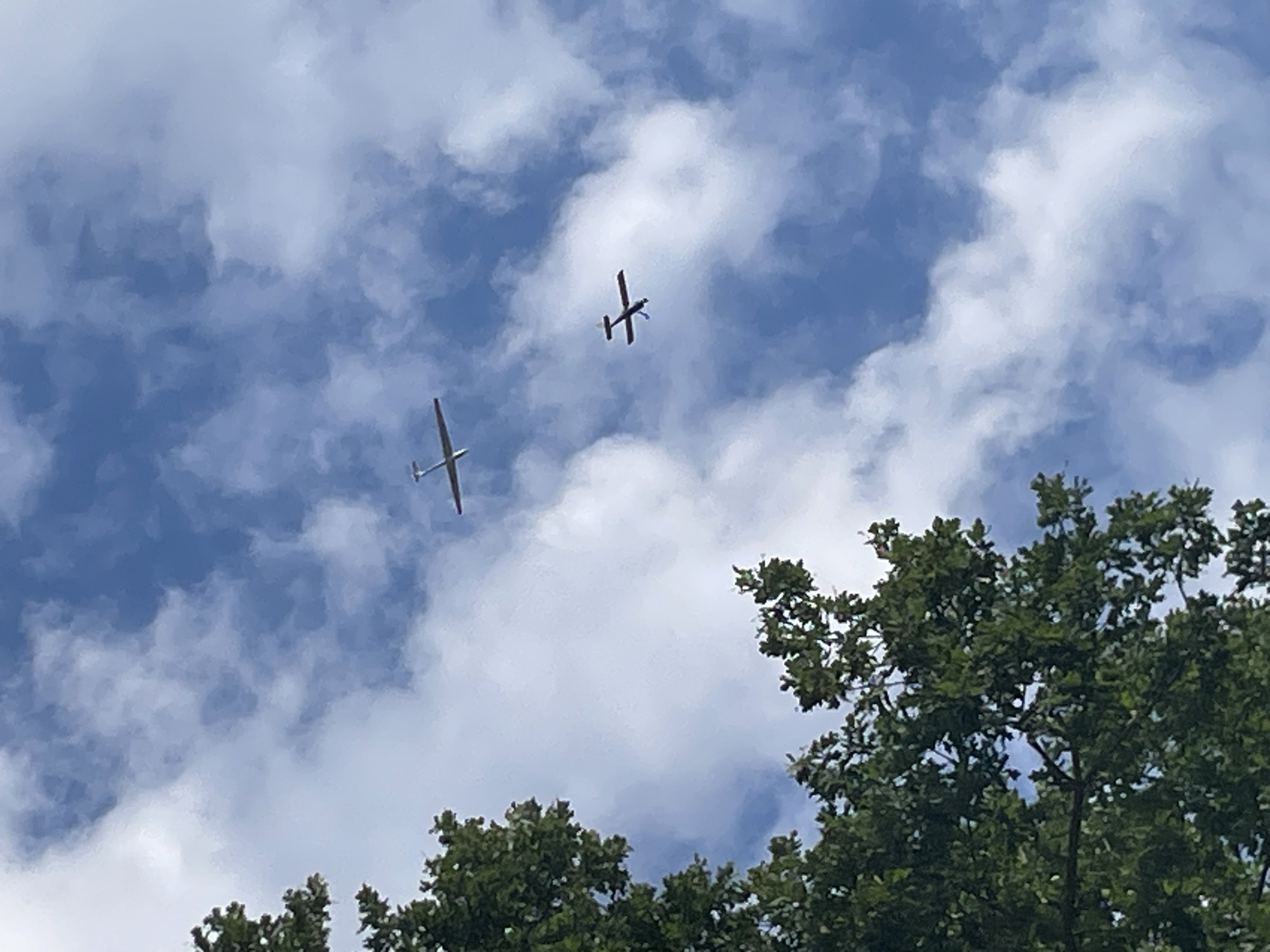 Two gliders soaring through a cloud-filled sky over Schrecksbach