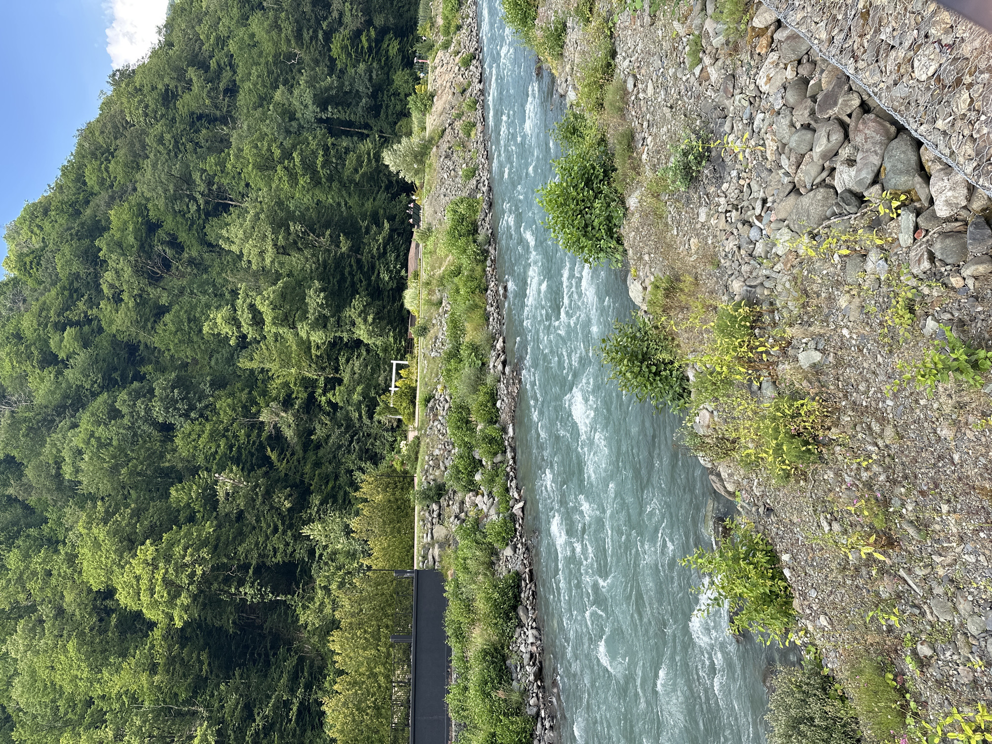 Turquoise river and mountain town, likely Russian Caucasus region