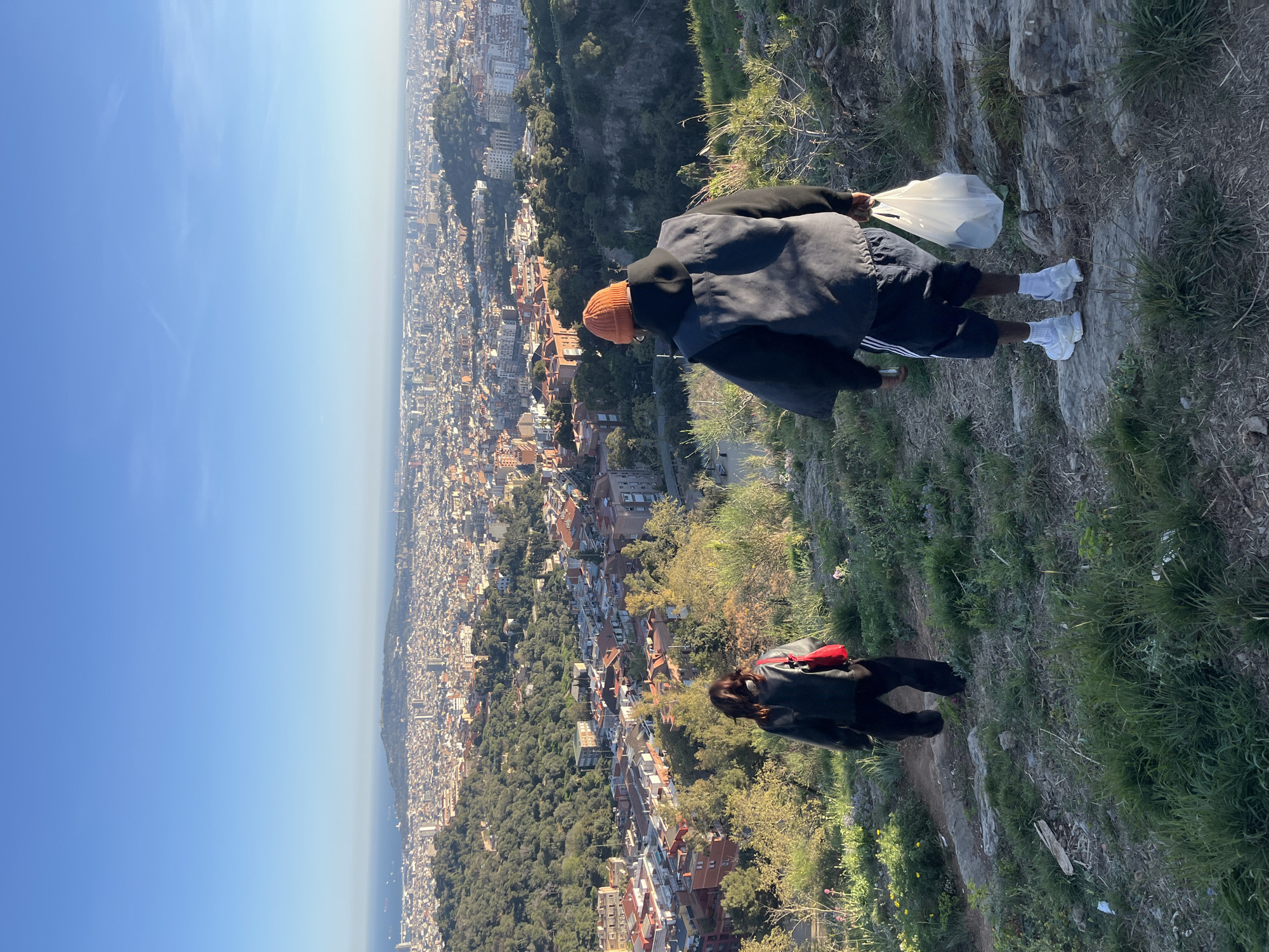 Person stands at elevated Barcelona viewpoint wearing distinctive outfit
