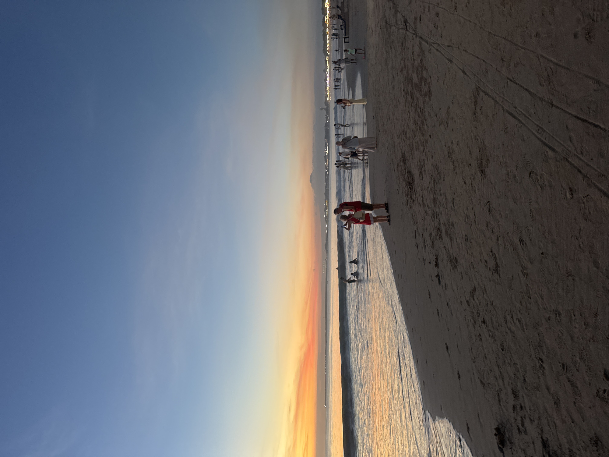 Two beachgoers with net observed during Kuta Selatan sunset