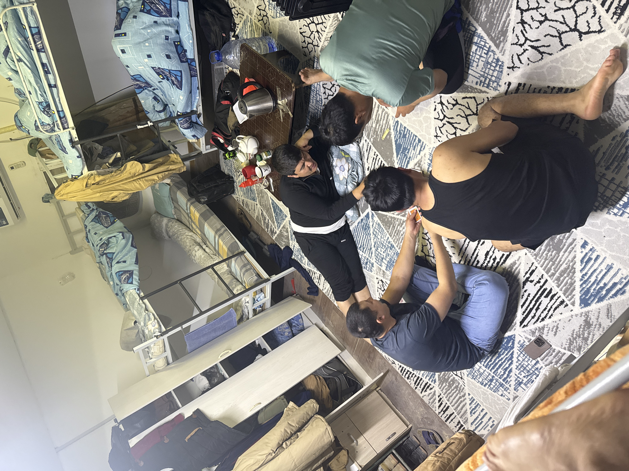 Four people gather around table in Almalyk dormitory