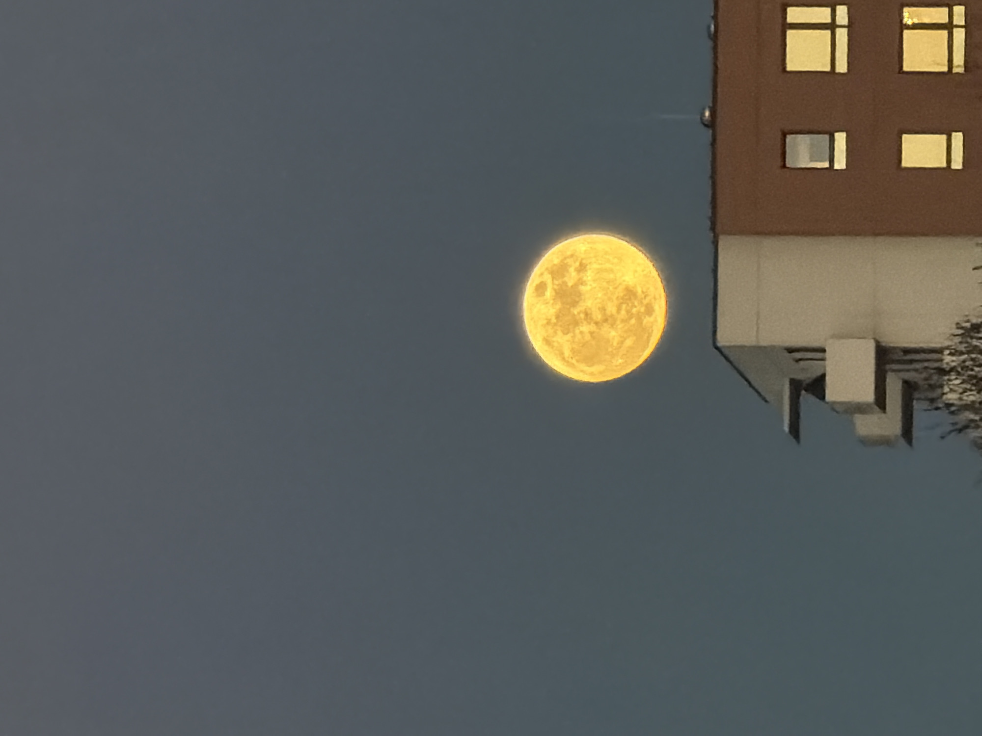 Full moon observed over Riga building at evening