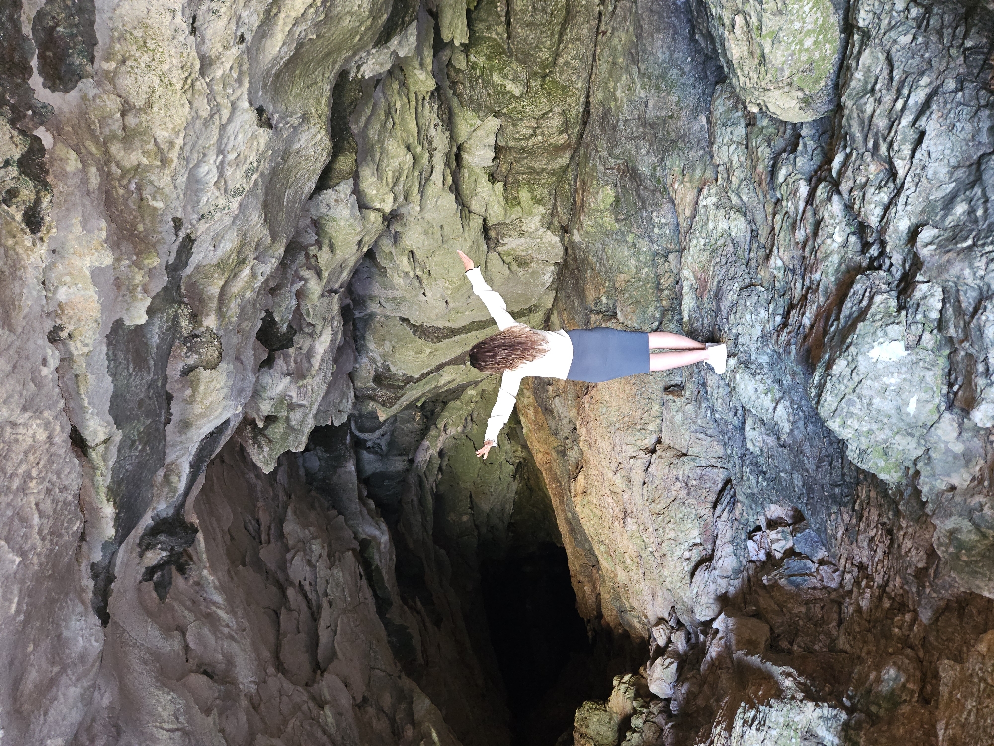 Woman in white shirt observed moving inside cave