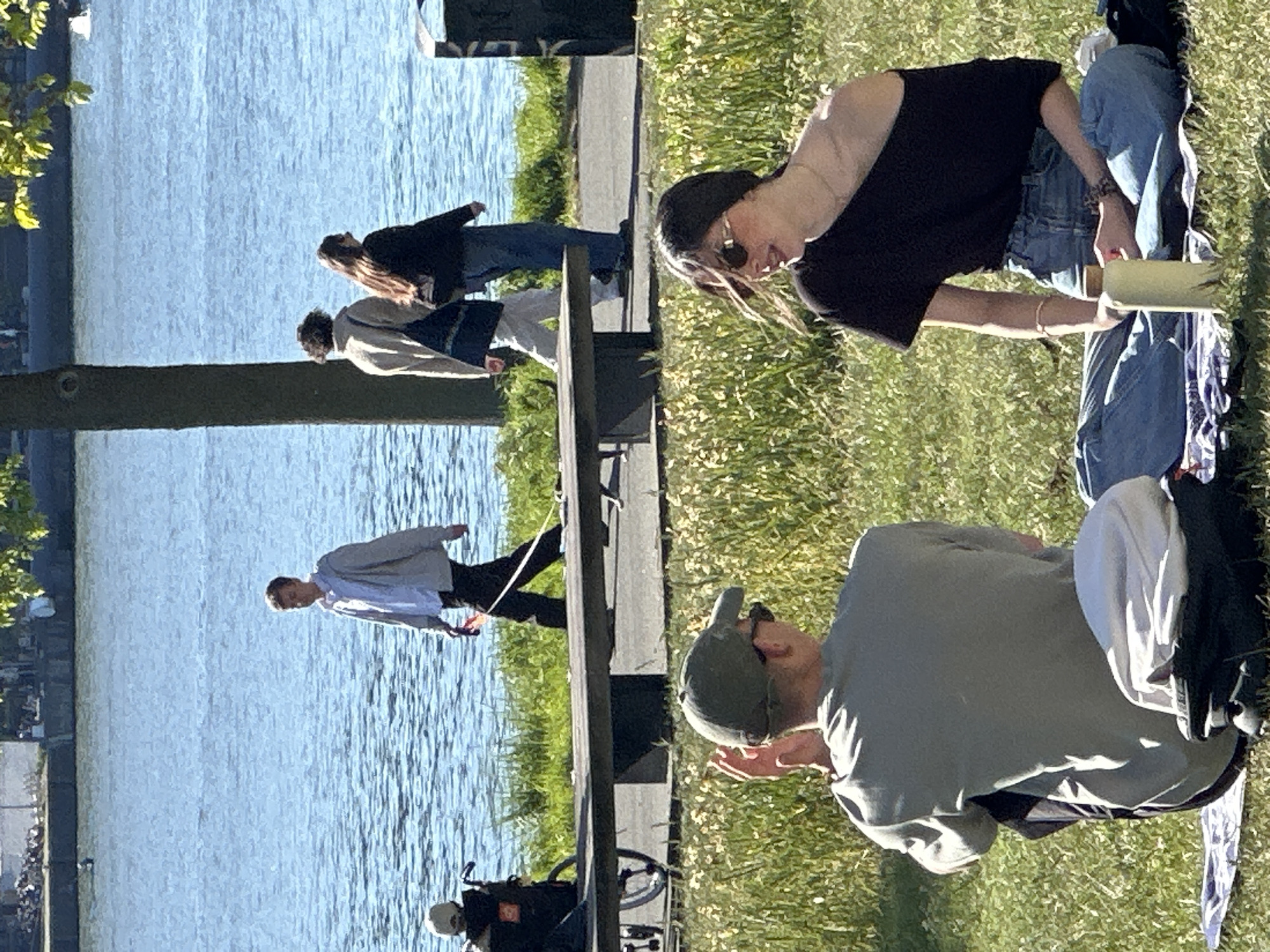People enjoy sunny afternoon leisure activities along Amsterdam canal