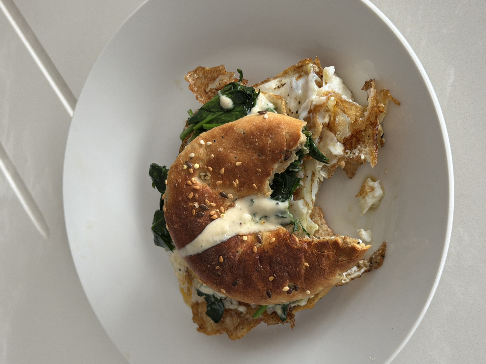 Half-eaten breakfast bagel sandwich documented in London