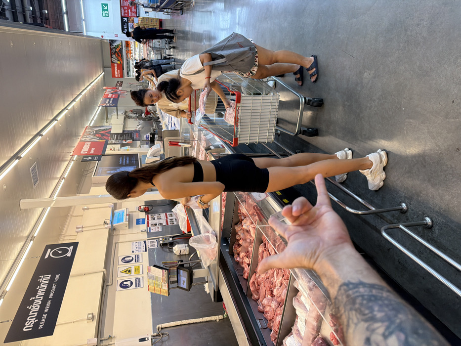 Tattooed shopper buys meat at Bangkok supermarket