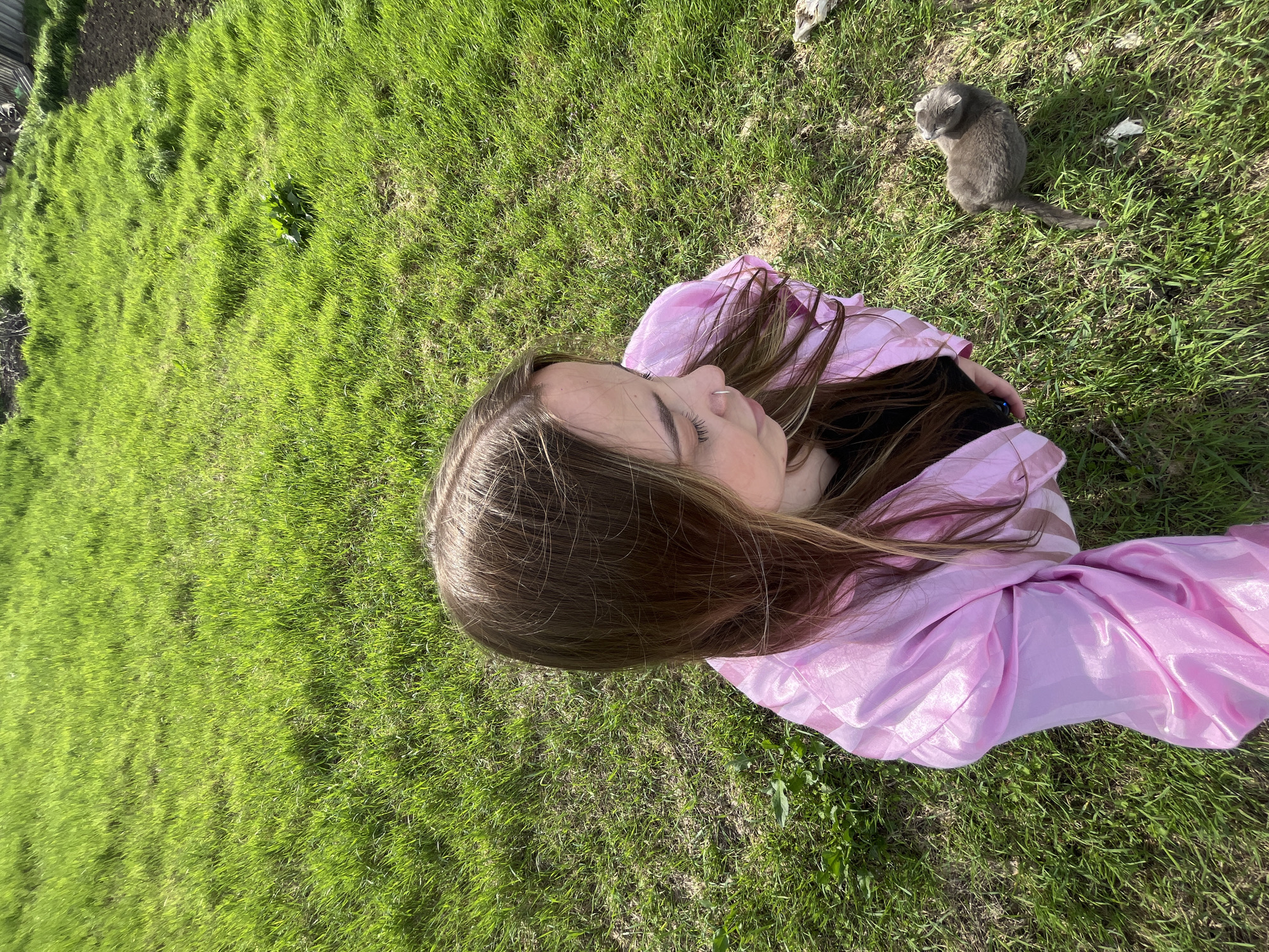 Woman and gray cat photographed on grass in Russia