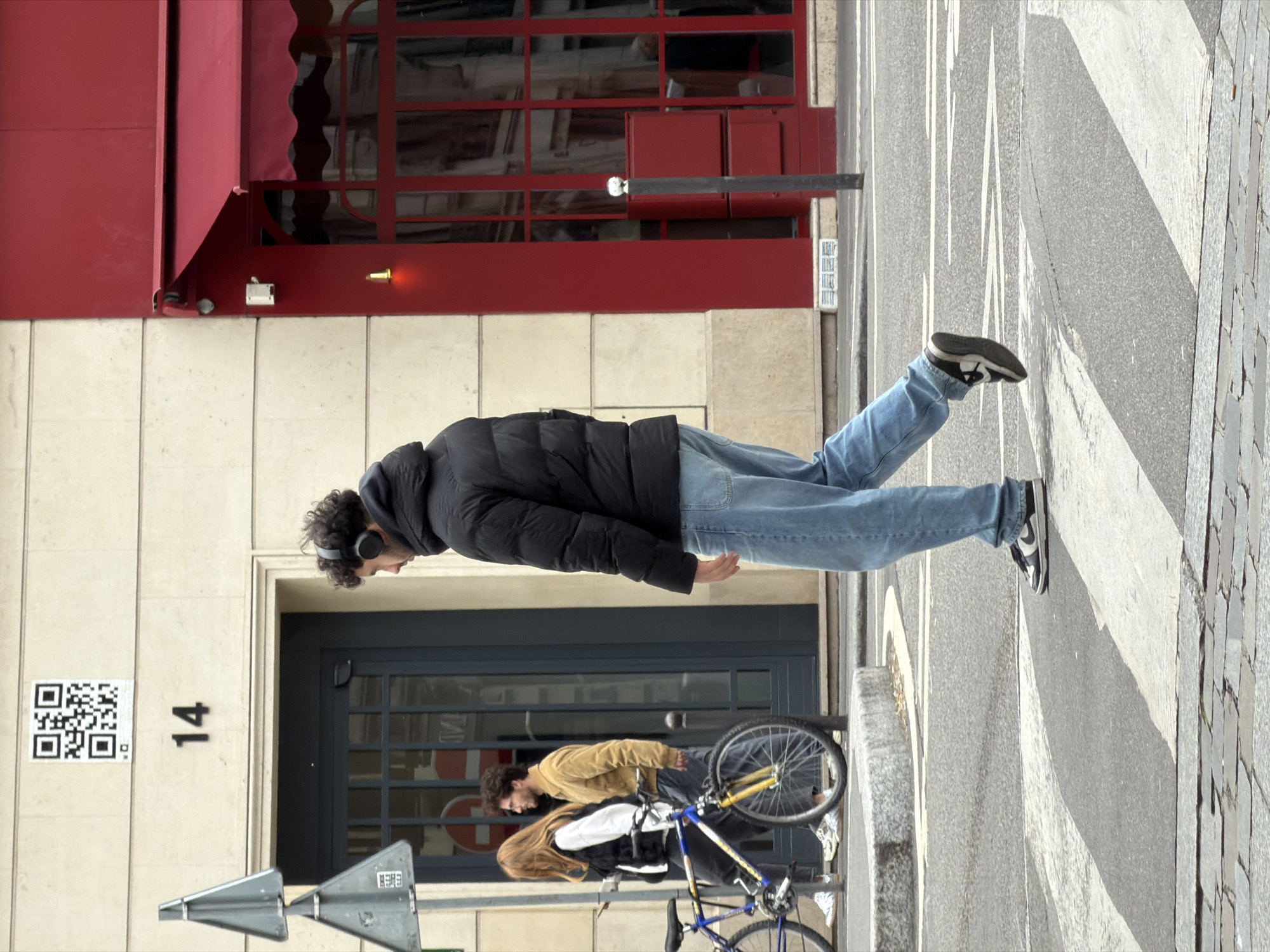 Man in headphones walks Paris sidewalk Friday morning